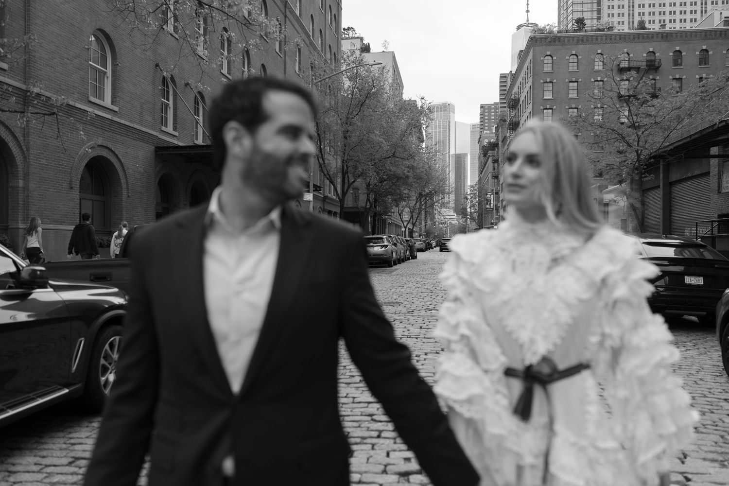 A couple shares intimate moments on a historic cobblestone street.