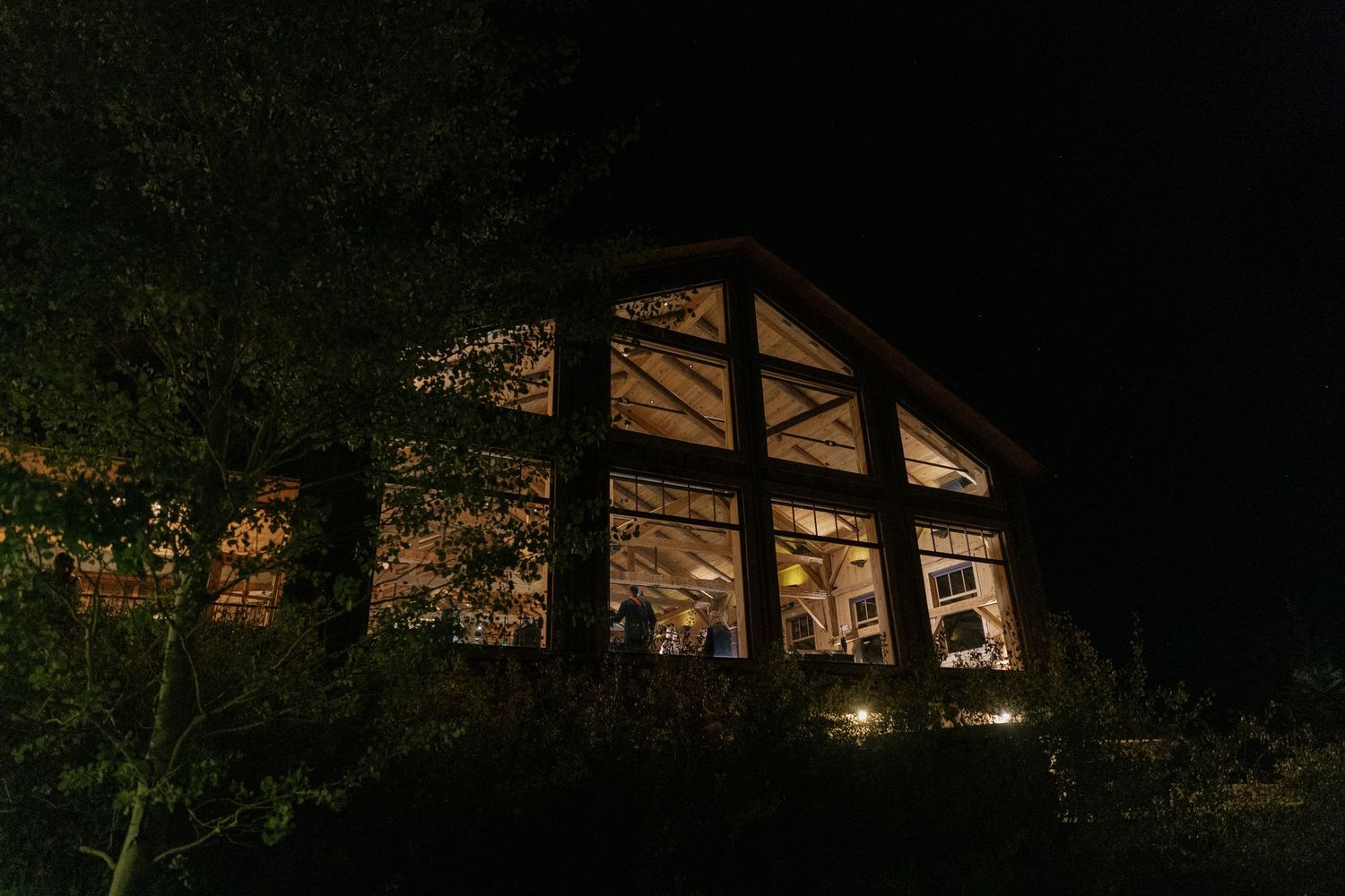 Illuminated rustic barn venue glowing in the darkness against a night sky.