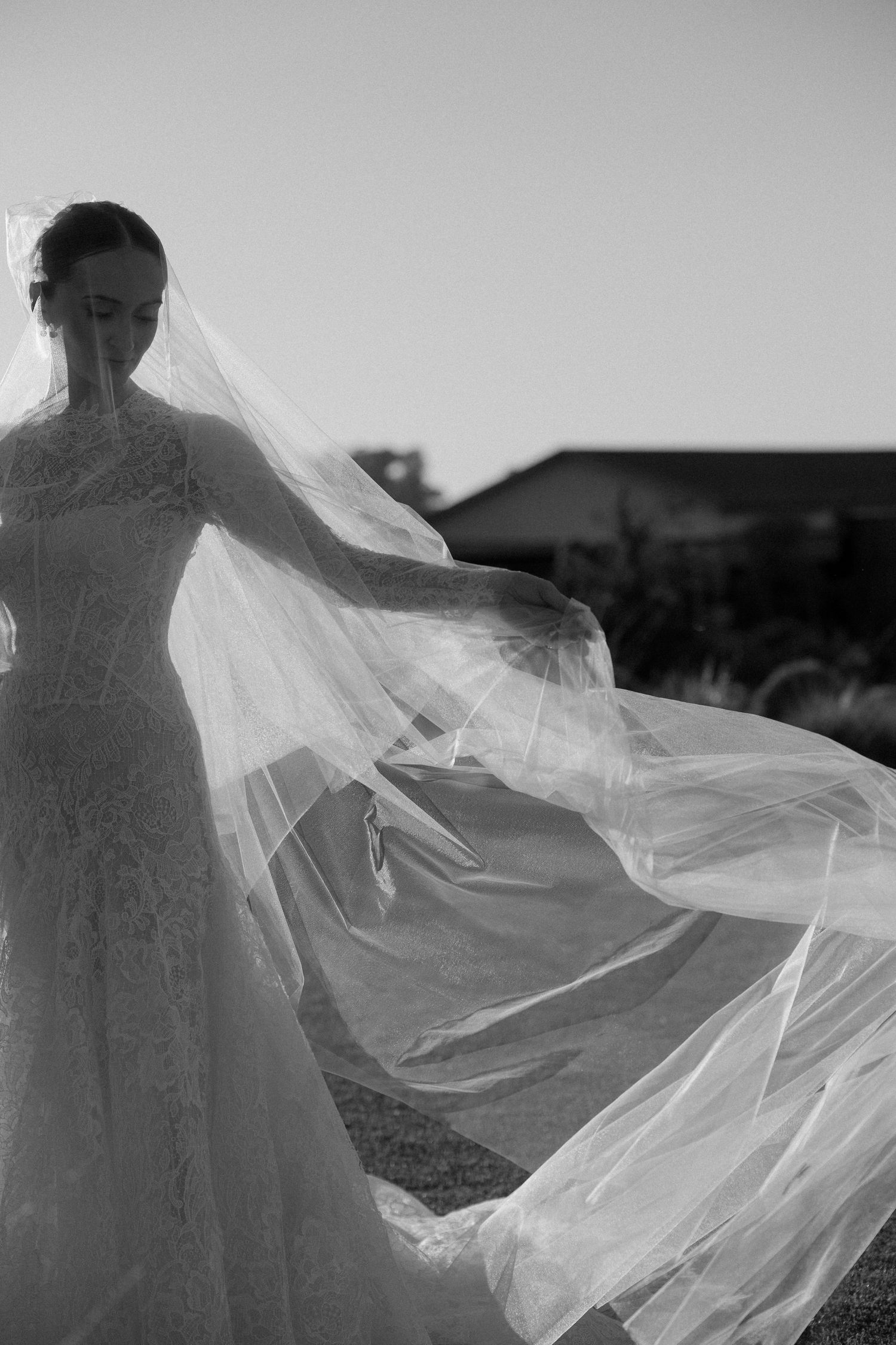 Artistic black and white photo of a flowing wedding veil caught in the wind.