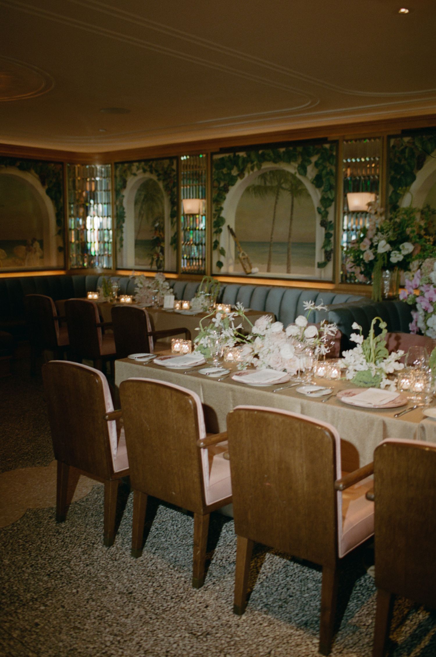 Luxurious dining room with arched mirrors and elegant place settings for formal event.