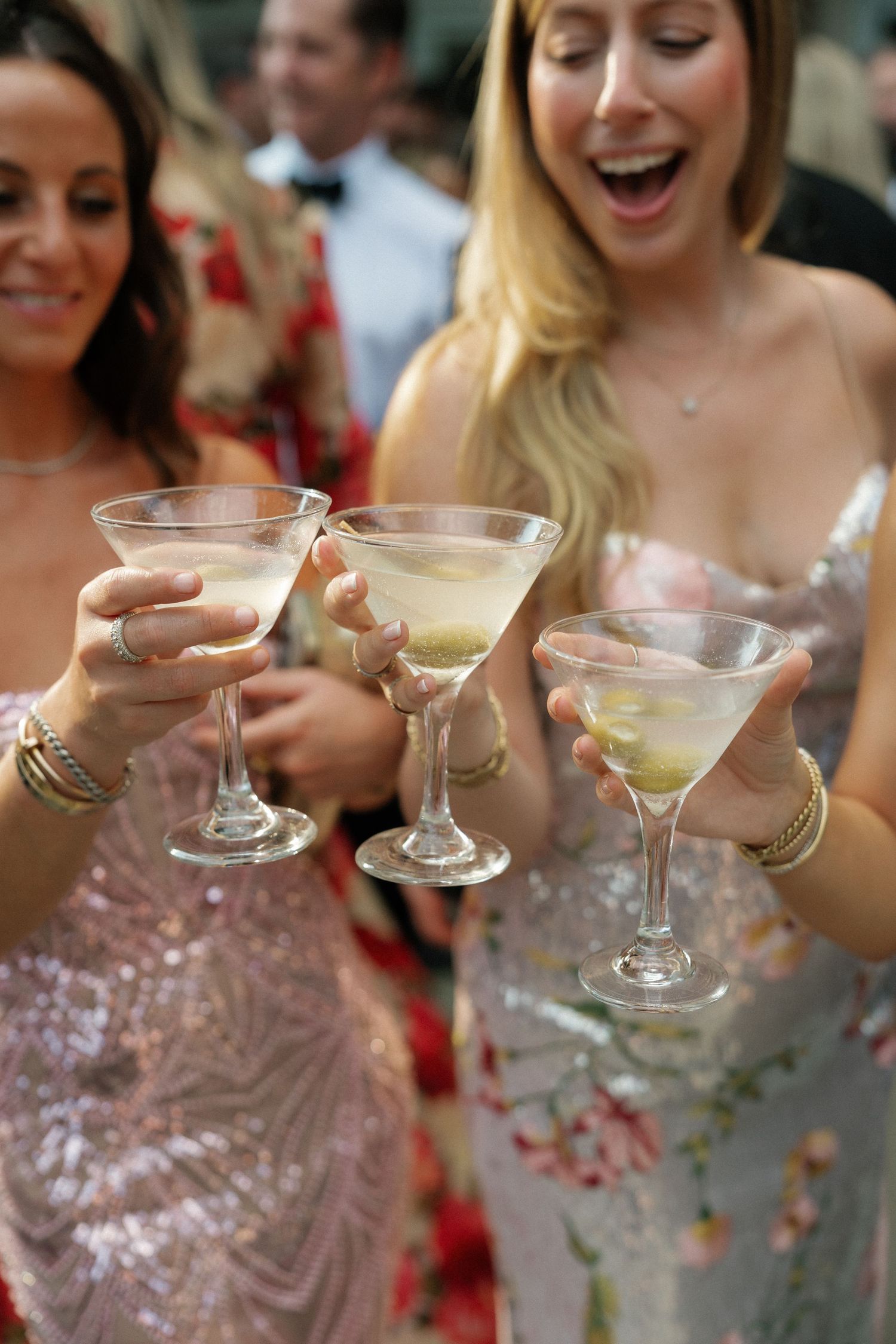 Close-up of martini glasses being held during a wedding celebration toast.