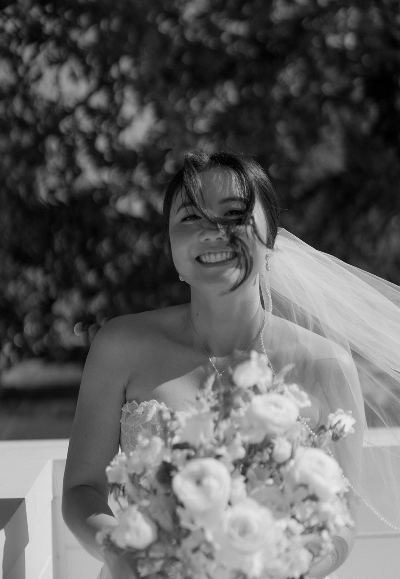Black and white portrait of a bride holding a classic white bouquet.