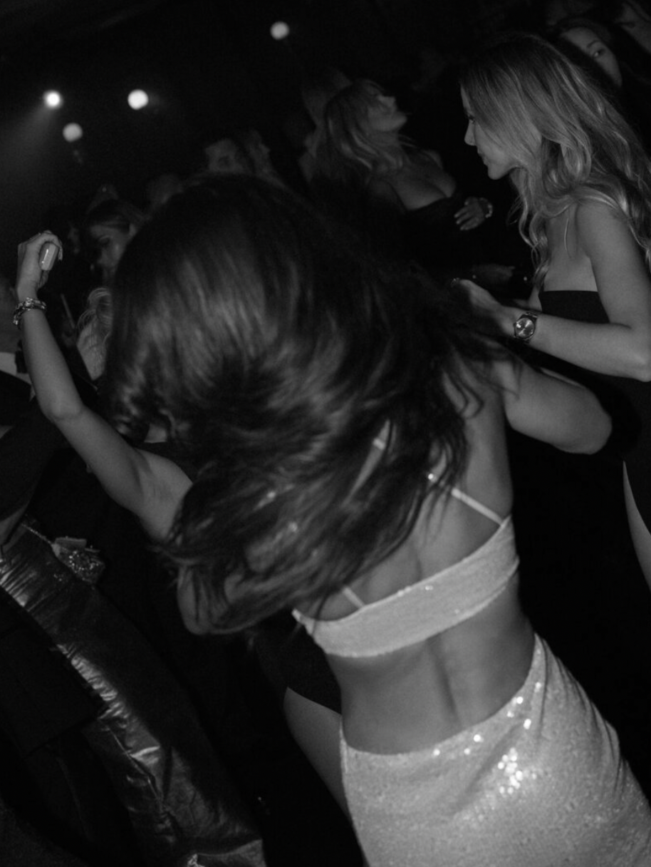 Dance floor scene with party lights and guests dancing at a nighttime celebration.