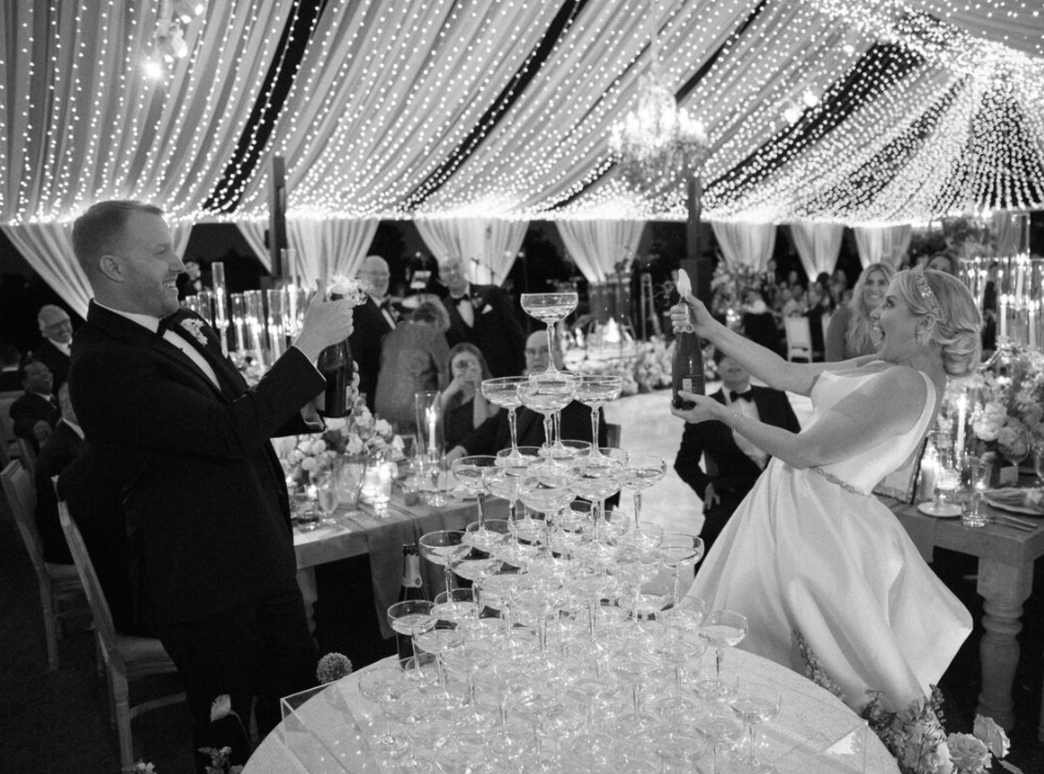 Crystal chandeliers and string lights create a romantic ambiance at an elegant wedding reception.