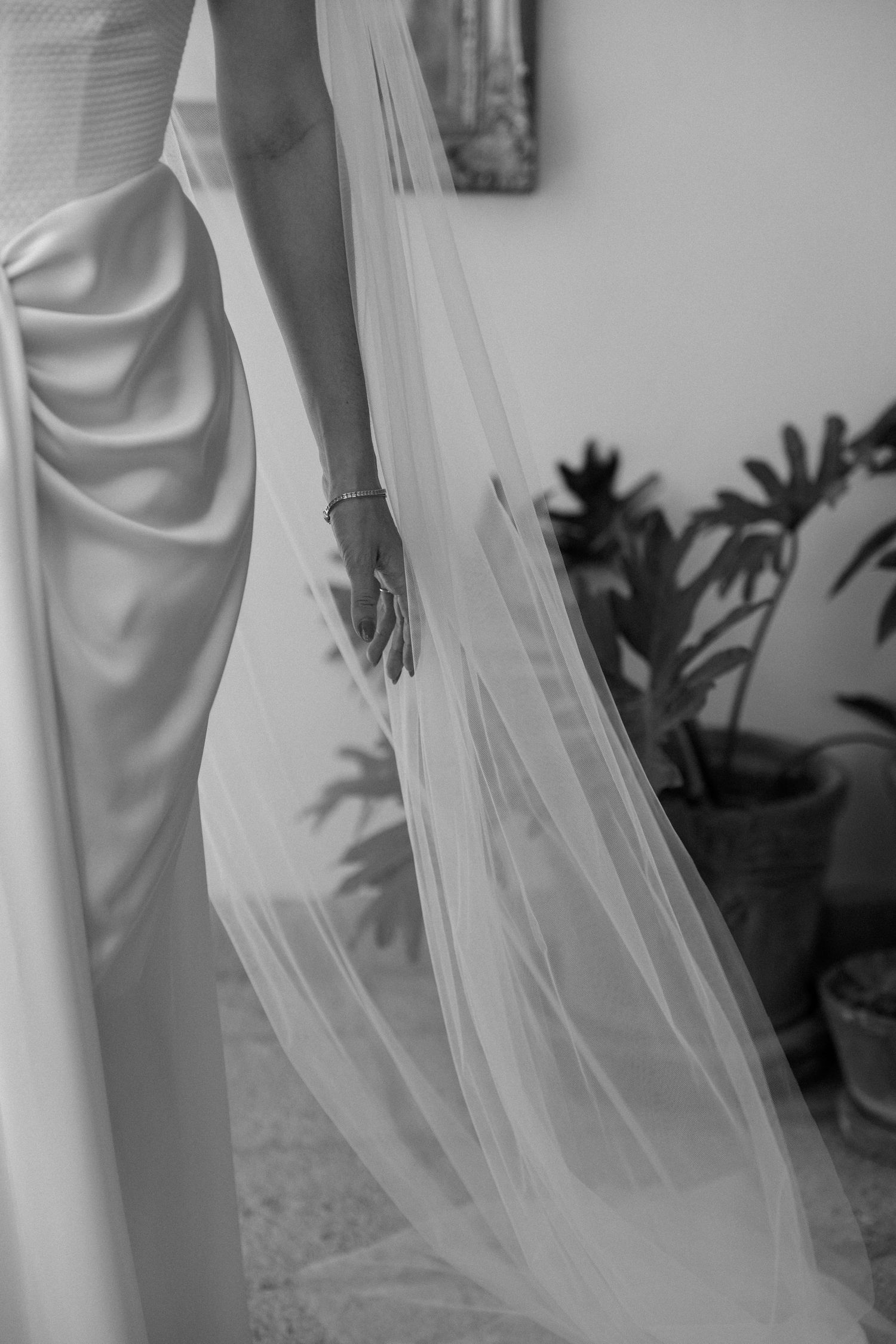 Close-up details of flowing white wedding dress fabric and veil.
