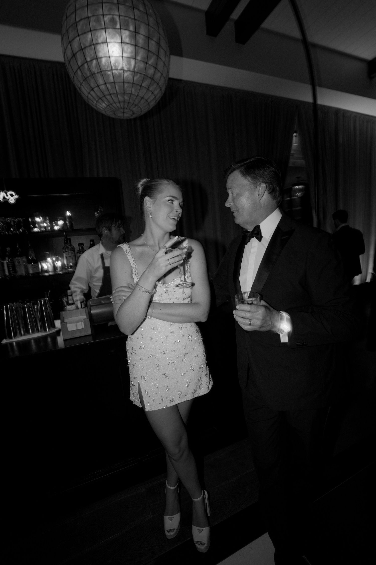 Couples dancing under a disco ball at a formal event.