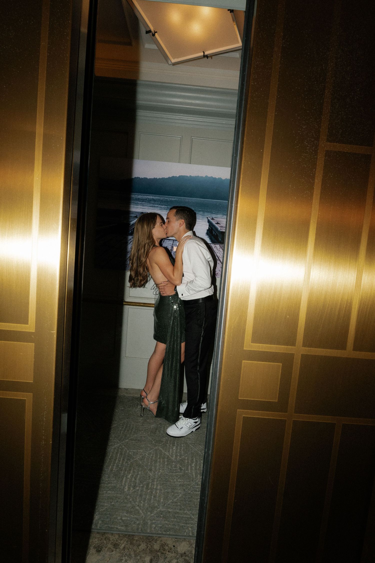 Dimly lit hallway scene with warm gold lighting and carpeted floors.