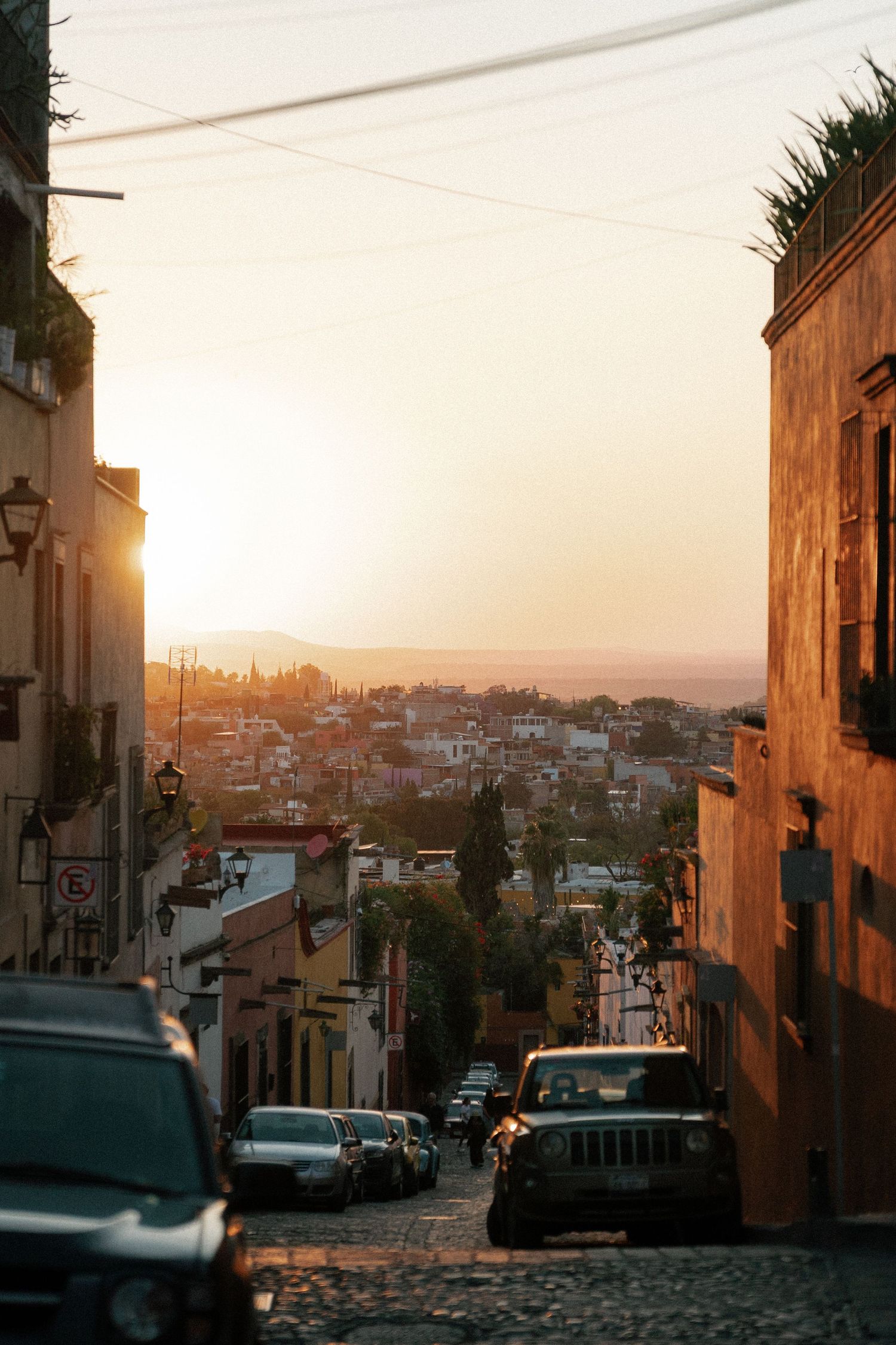 Sunset view of a cobblestone street in San Miguel de Allende with warm golden light.