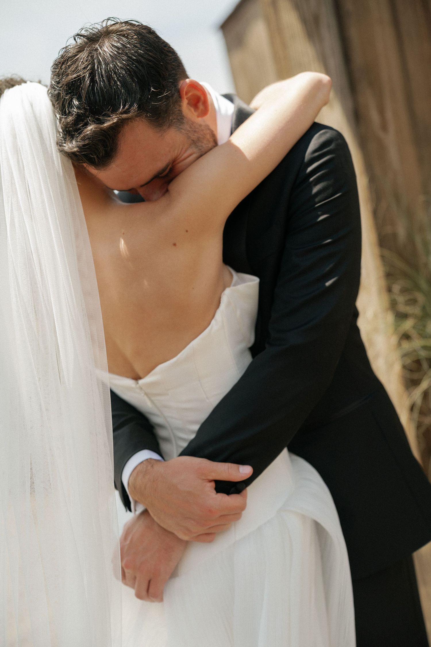 Close-up details of romantic wedding embrace in black and white.