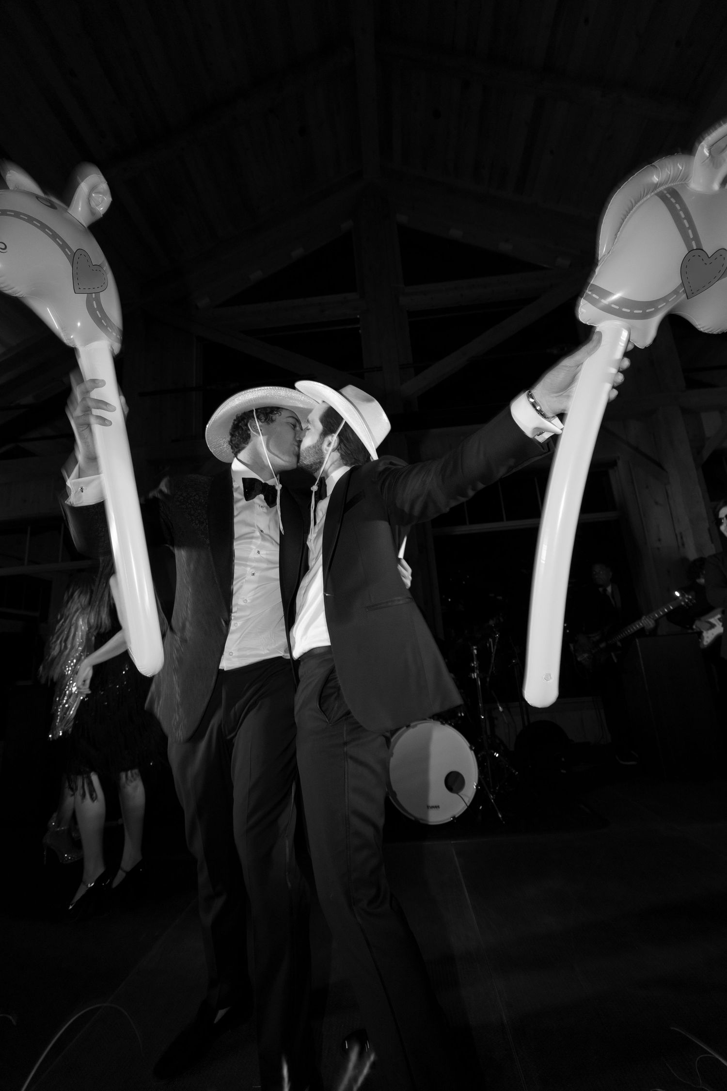 Wedding reception dance floor with silhouettes of people dancing in dark lighting.