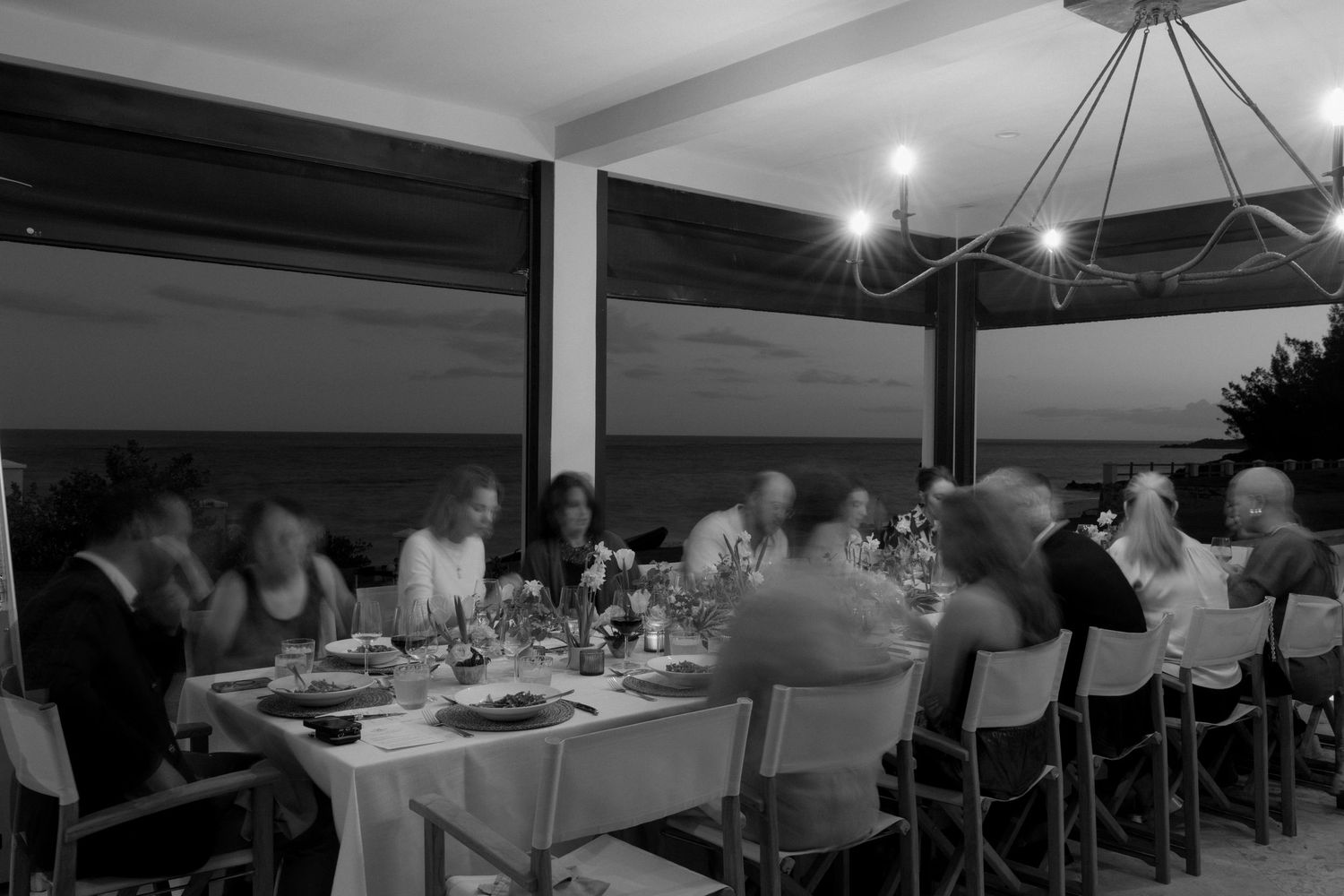 A group of people dining at a table in a dimly lit restaurant.