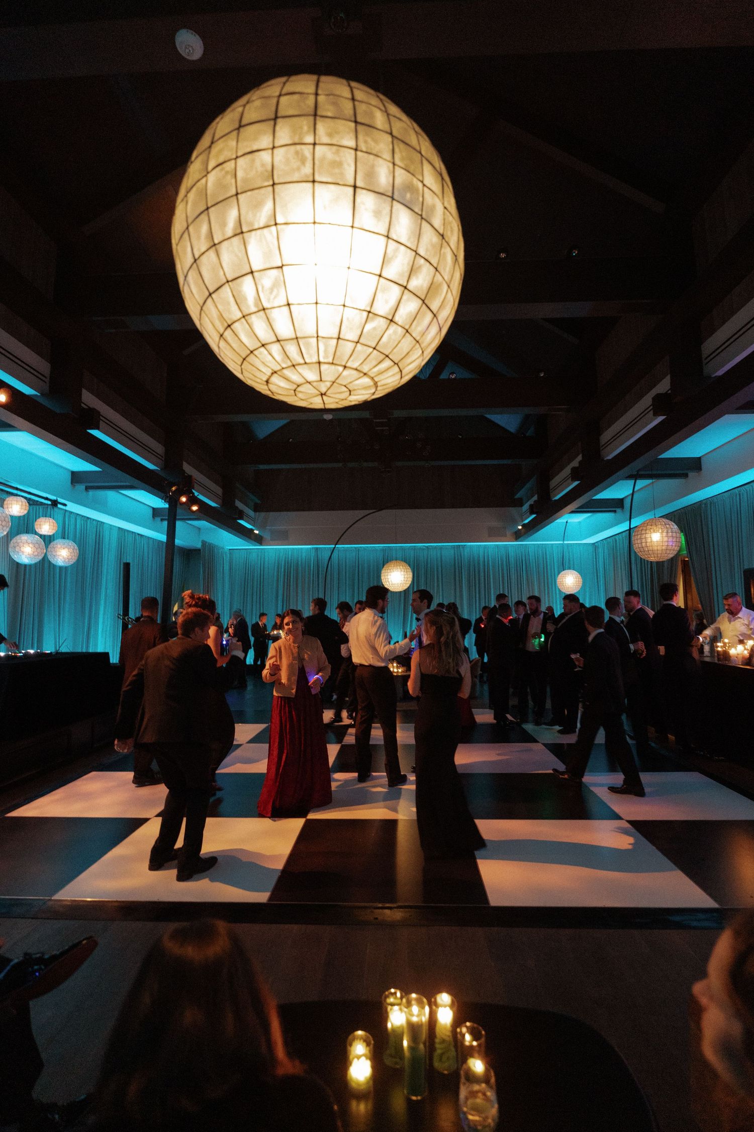 Elegant reception venue with glowing paper lanterns and blue ambient lighting creating a modern atmosphere.