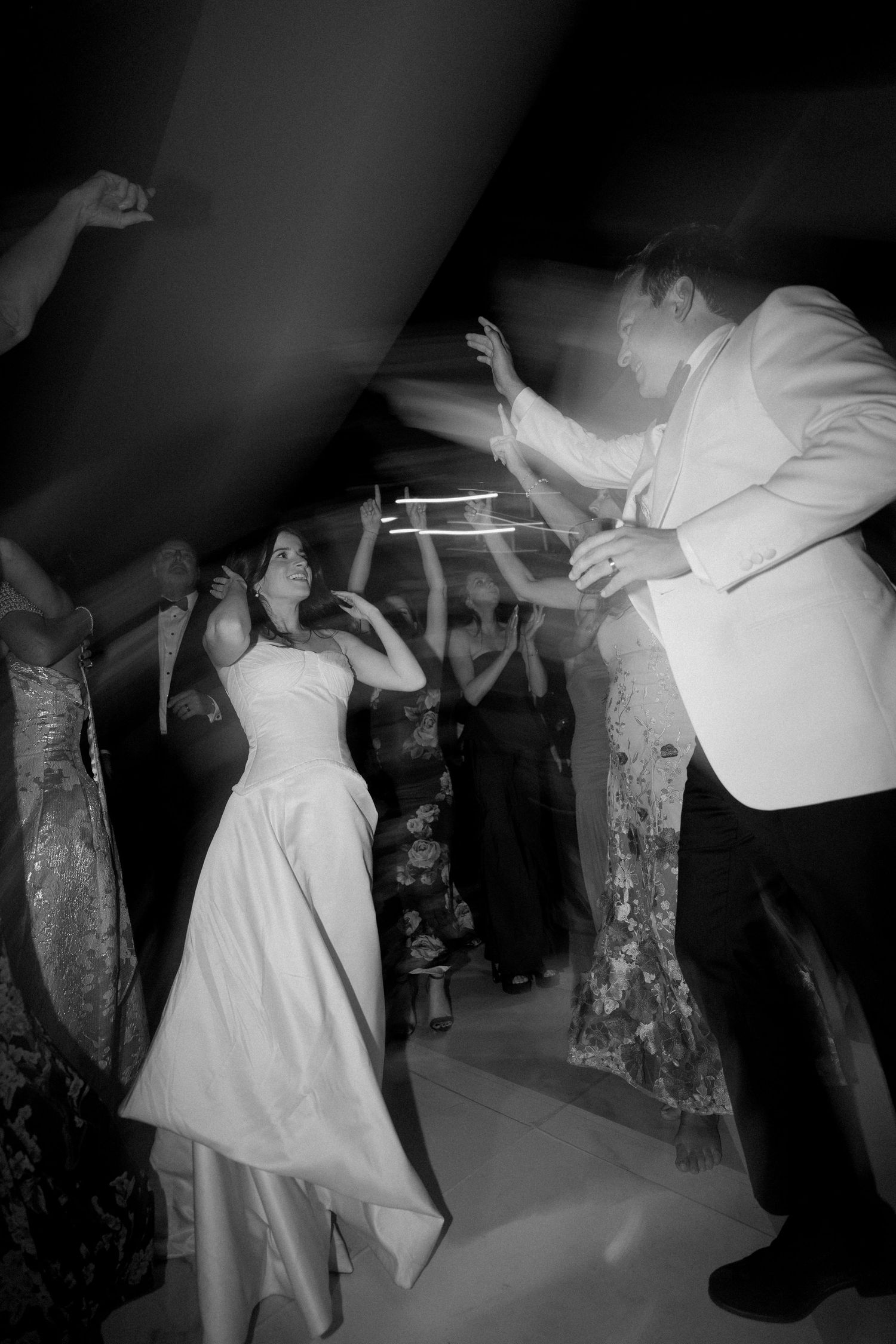 Wedding reception dance floor scene with people dancing in black and white.