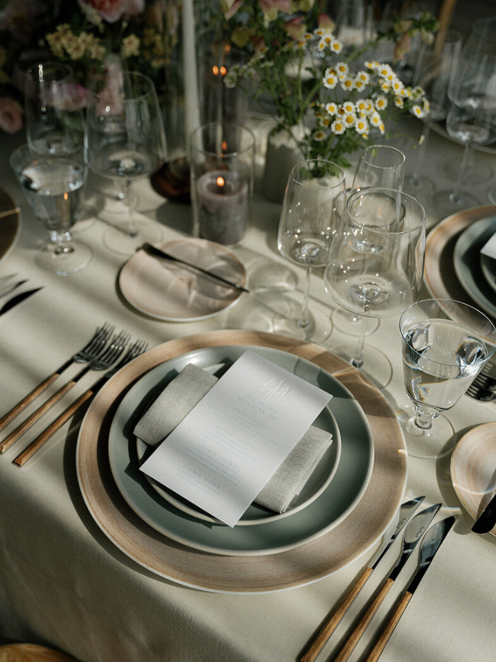 Elegant table setting with silver chargers, white plates and crystal glassware for a formal dinner.