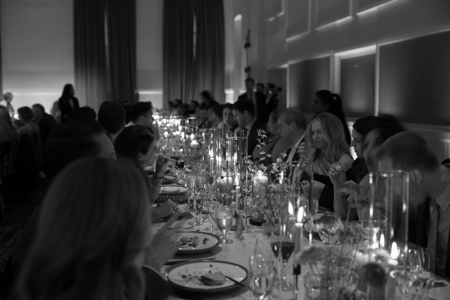 Elegant candlelit dinner table setting at a wedding reception in black and white.