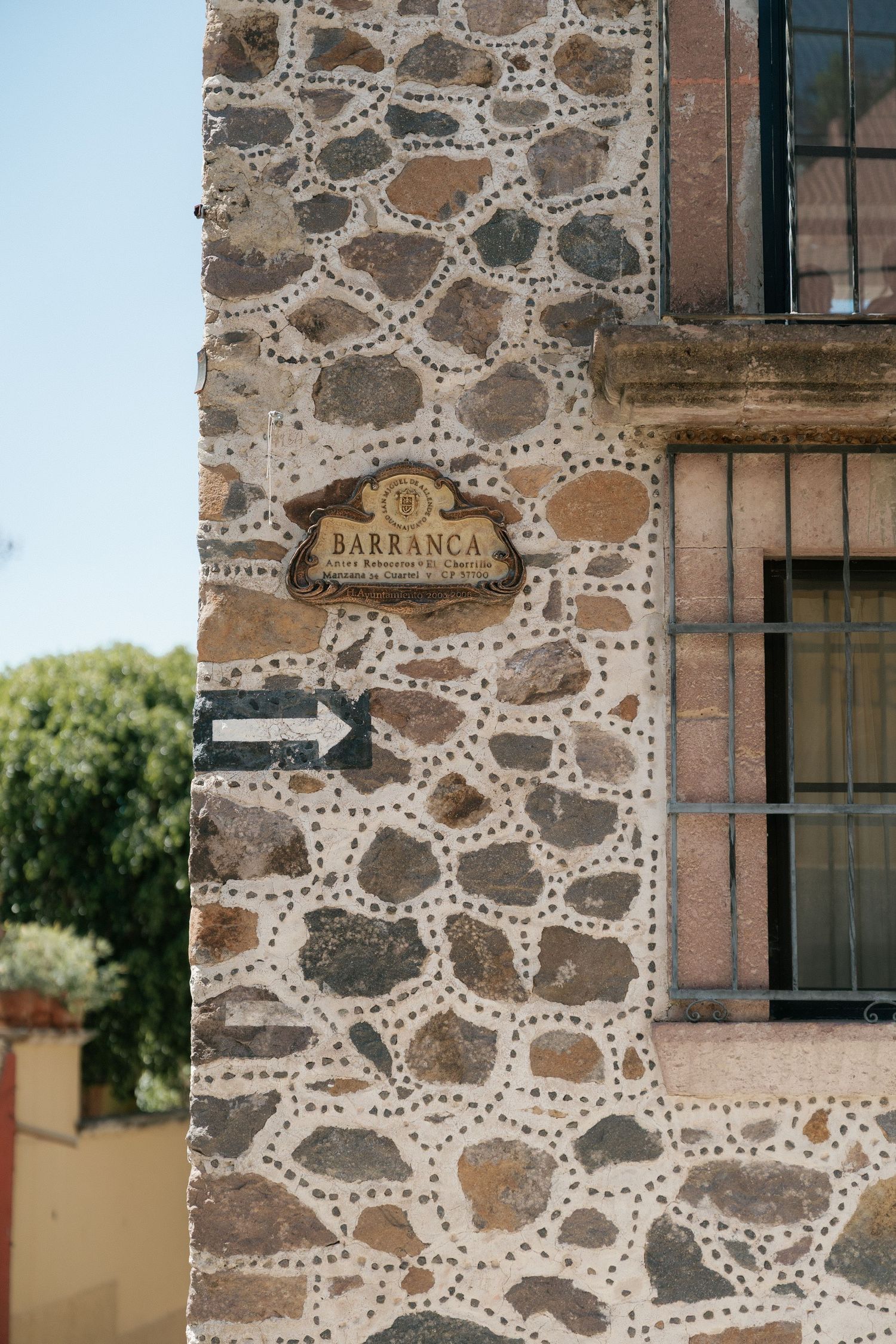 Close-up shots of stone wall texture with 'Barranca' sign and architectural details.