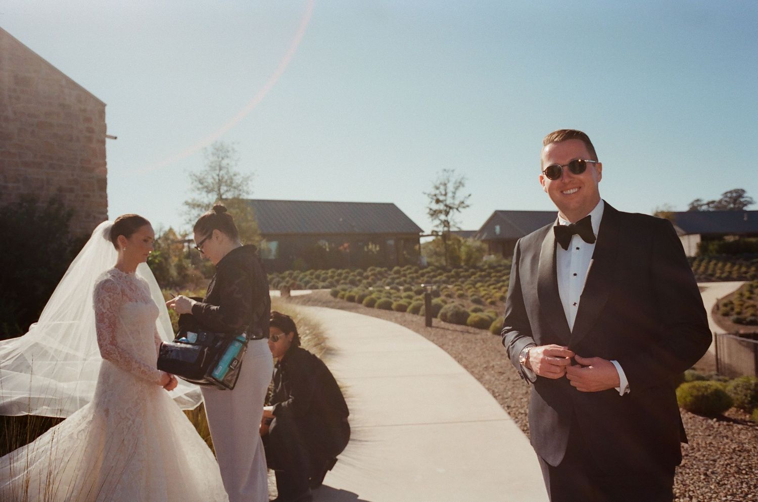 Wedding ceremony taking place on a paved pathway with desert landscape in the background.