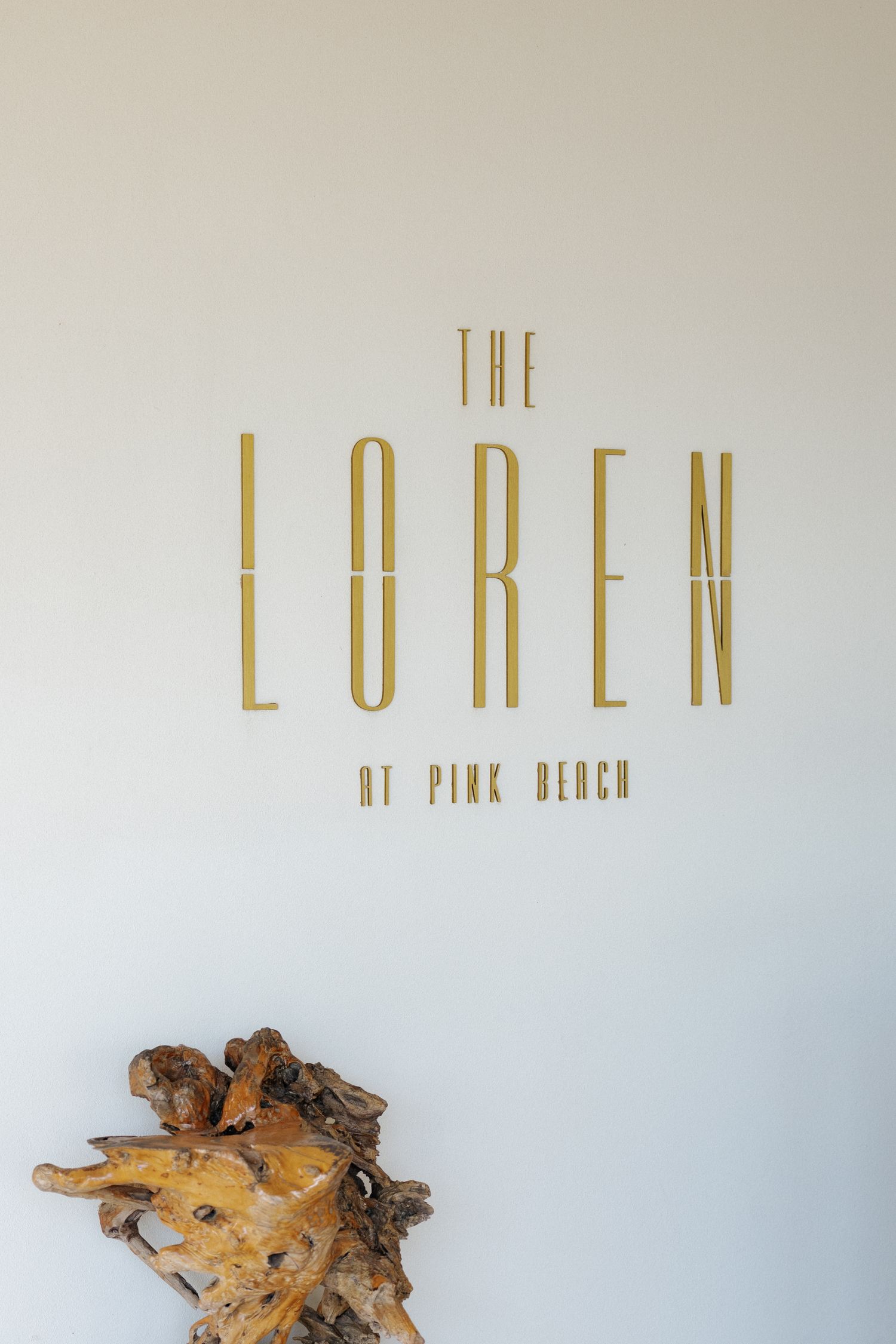 The logo for The Loren at Pink Beach, a luxury resort.