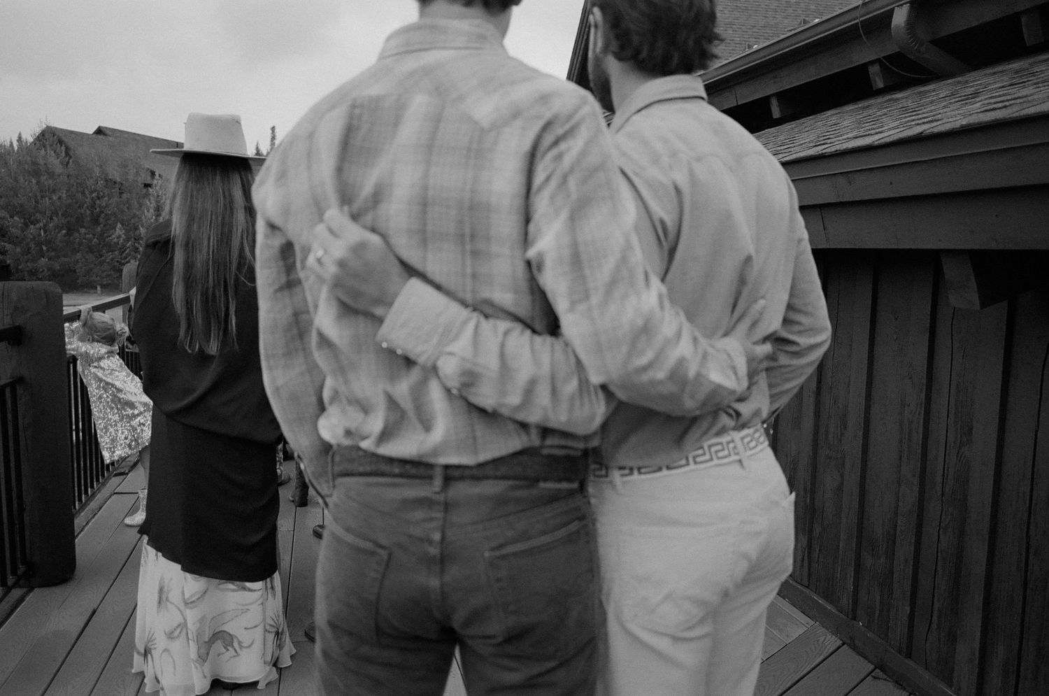 Candid moment between guests at rustic outdoor wedding reception.