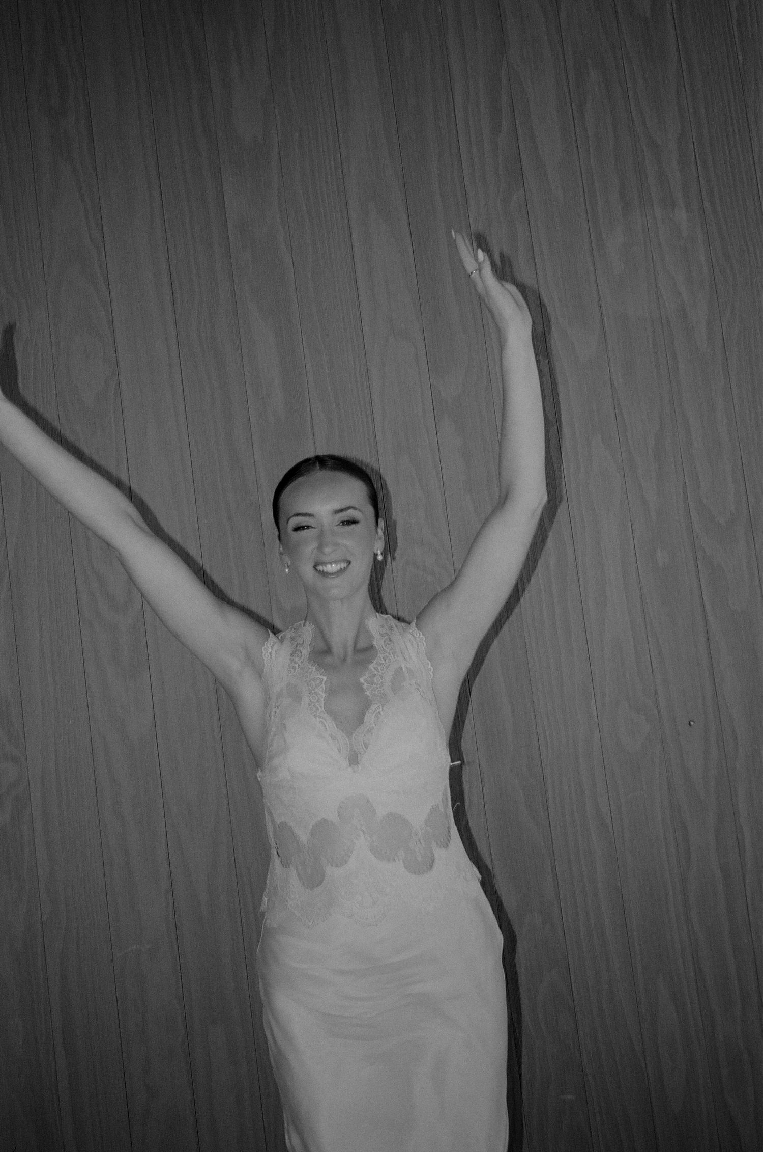 Dramatic black and white portrait showing movement in white lace dress.