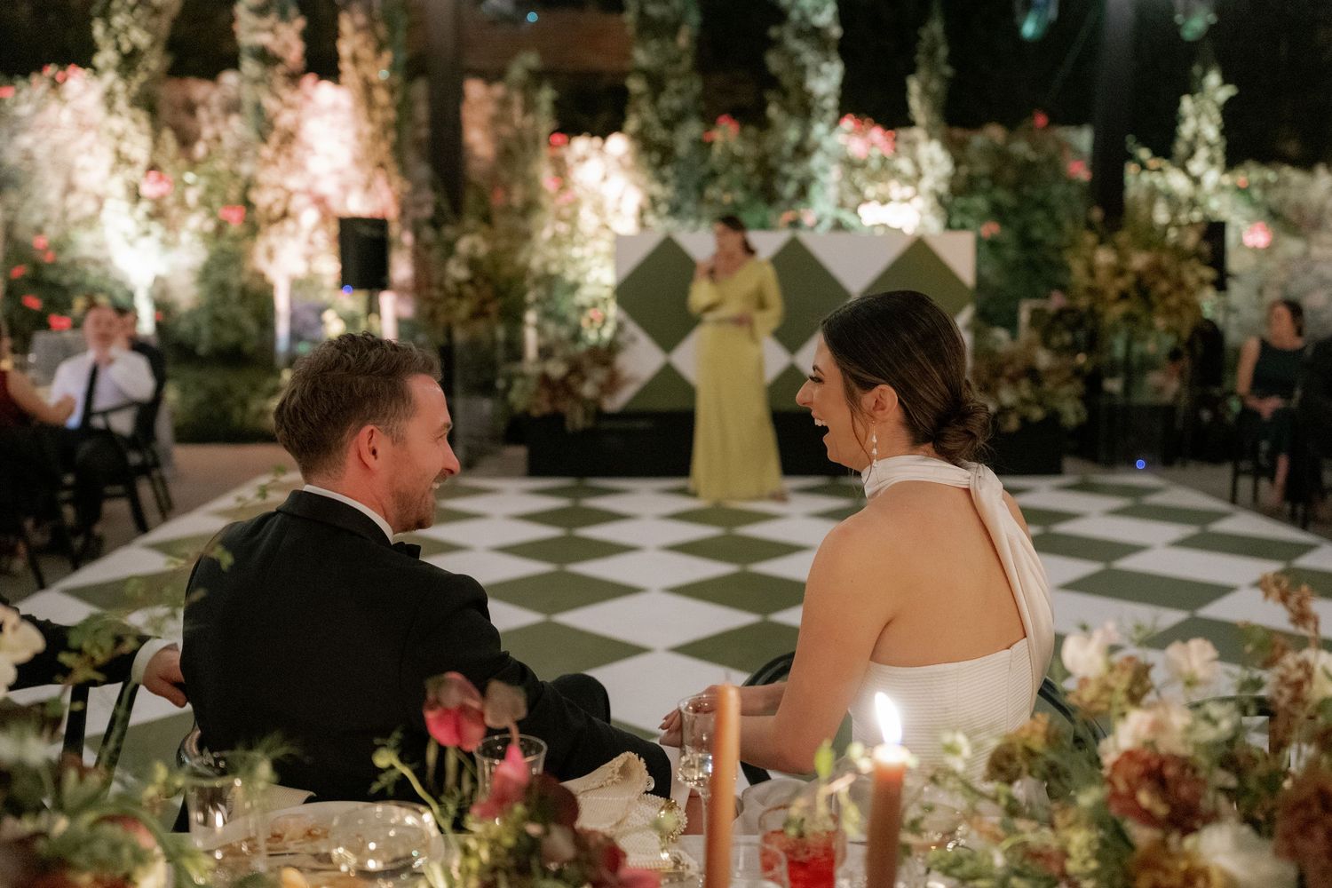 Elegant wedding reception venue with long tables decorated with floral arrangements and candles.