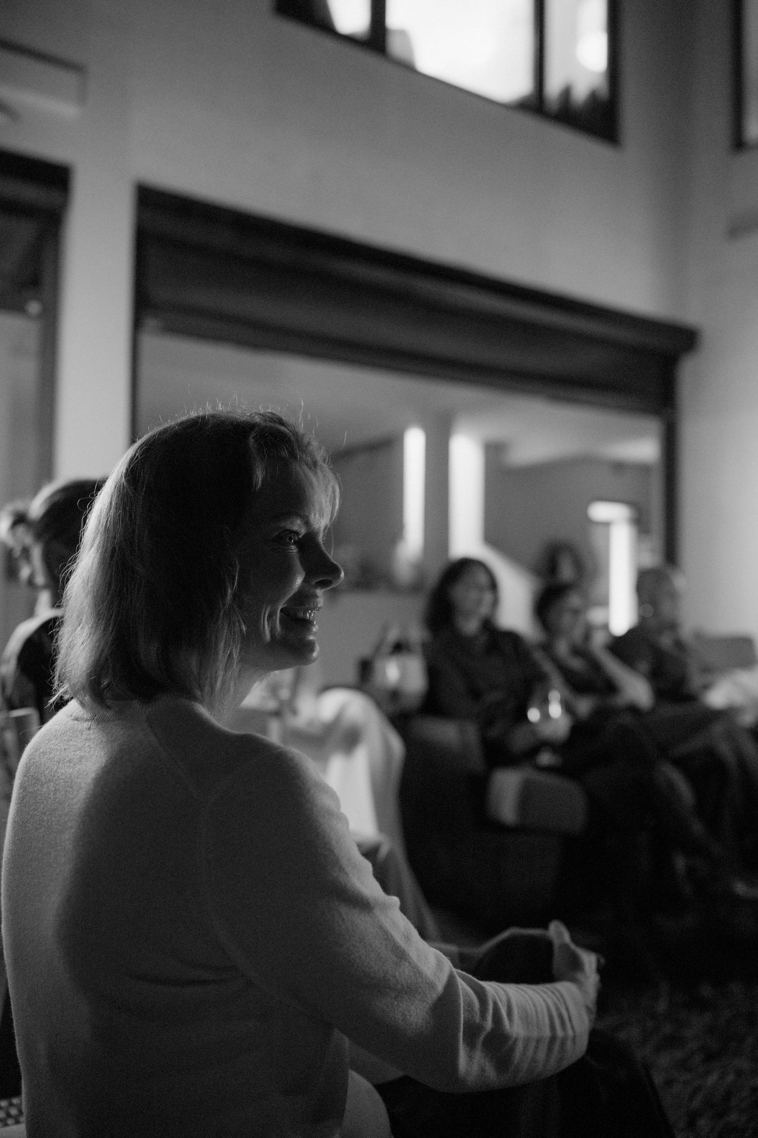 A black and white image of a woman with long hair in a crowd of people.