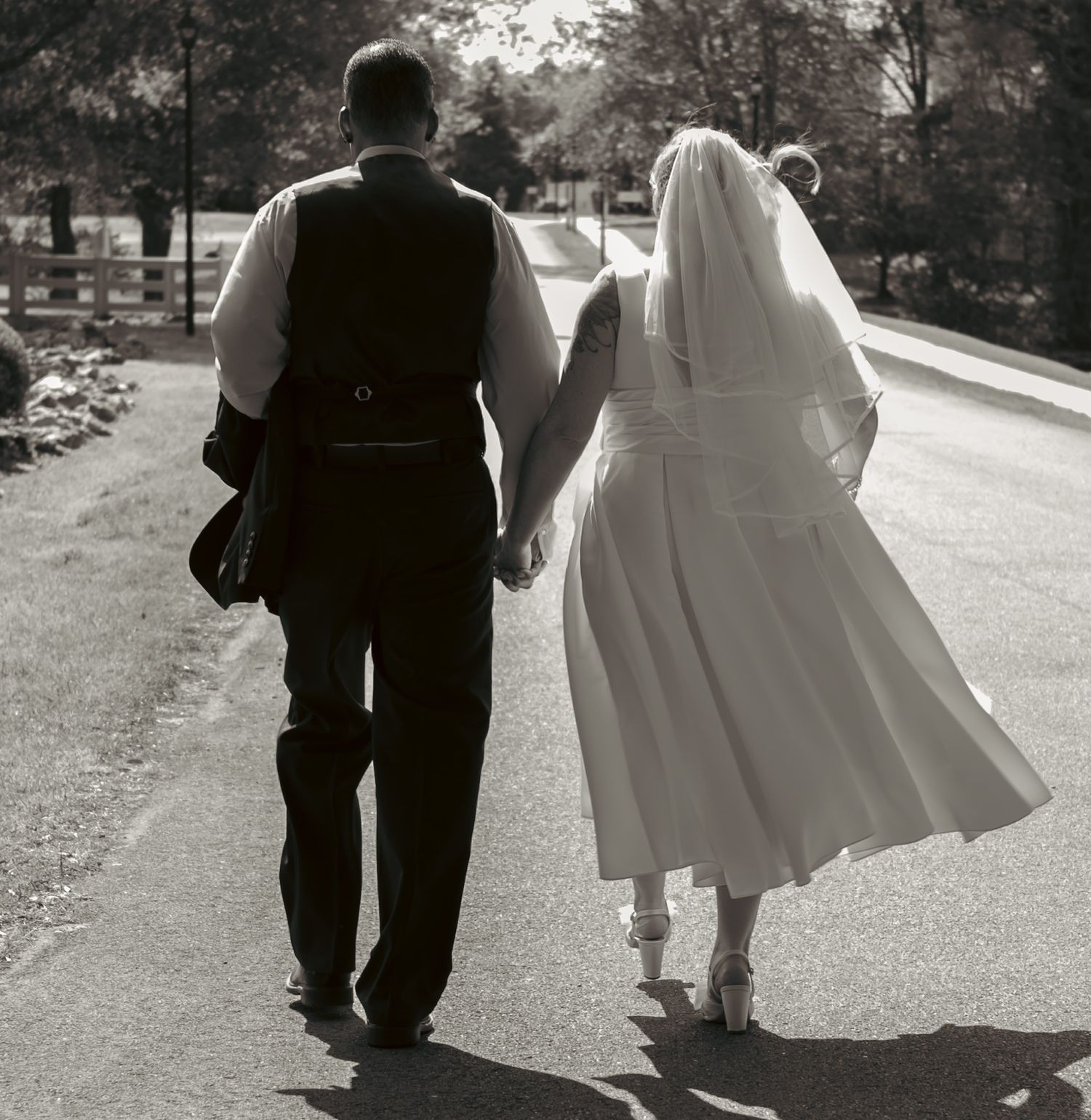 Black and white photo of couple walking together on garden path.