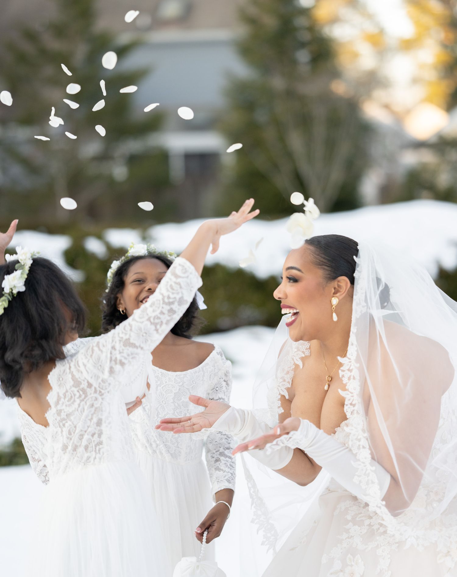 Joyful wedding party celebrating with confetti in the snow.