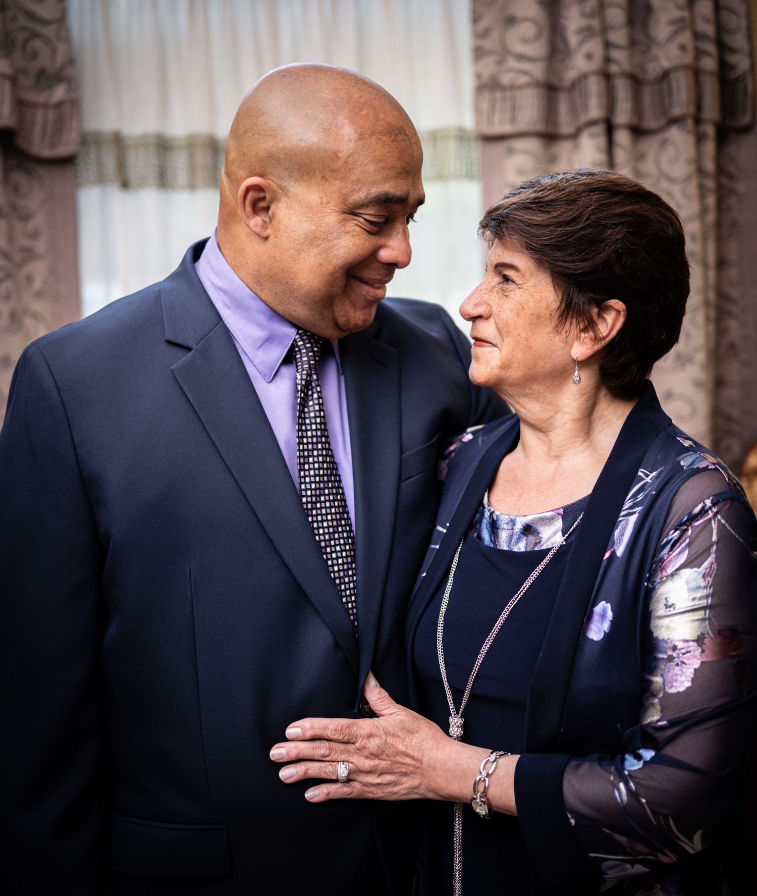 Elderly couple sharing an intimate moment in formal attire.