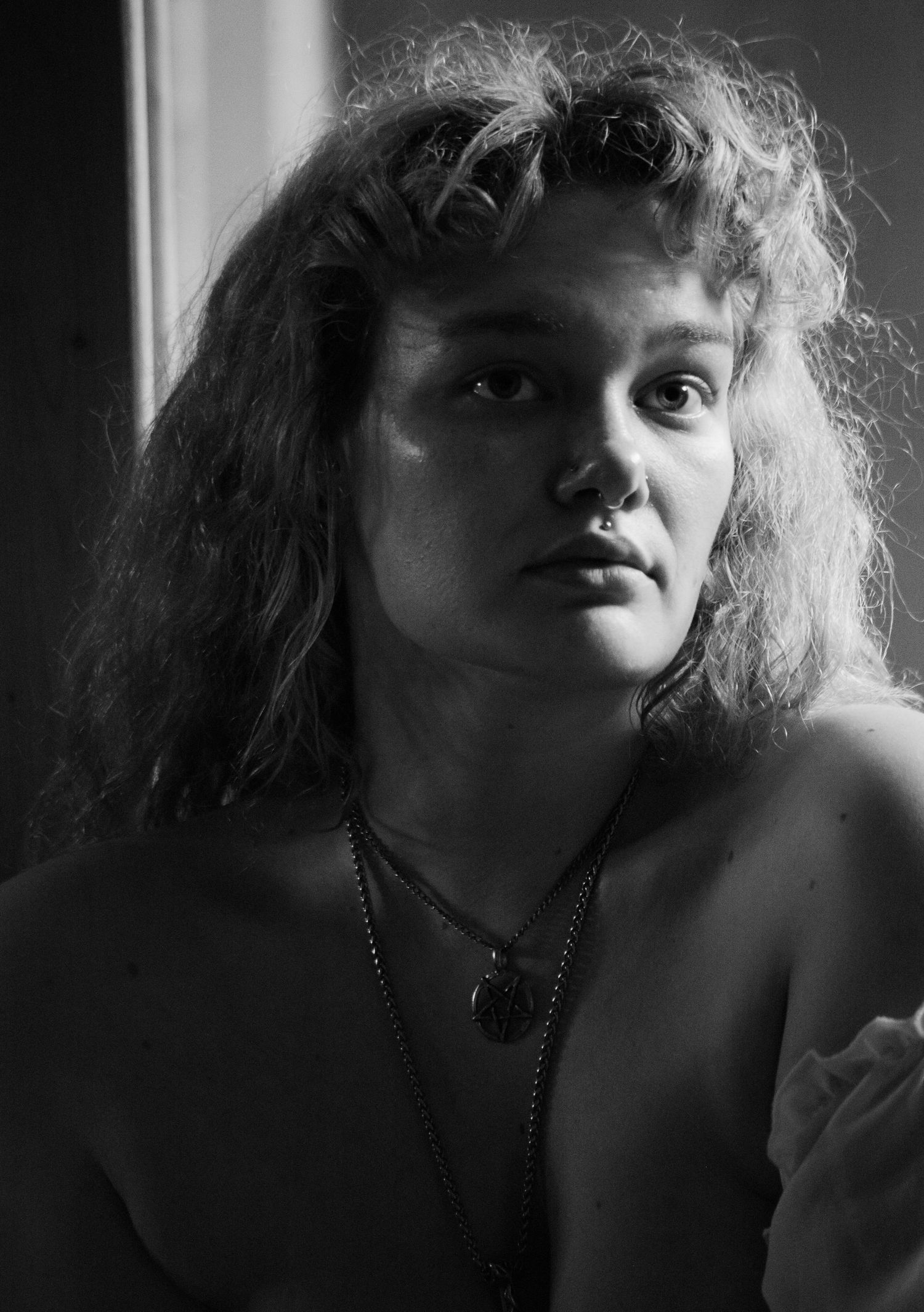Dramatic black and white portrait with moody lighting and textured hair.