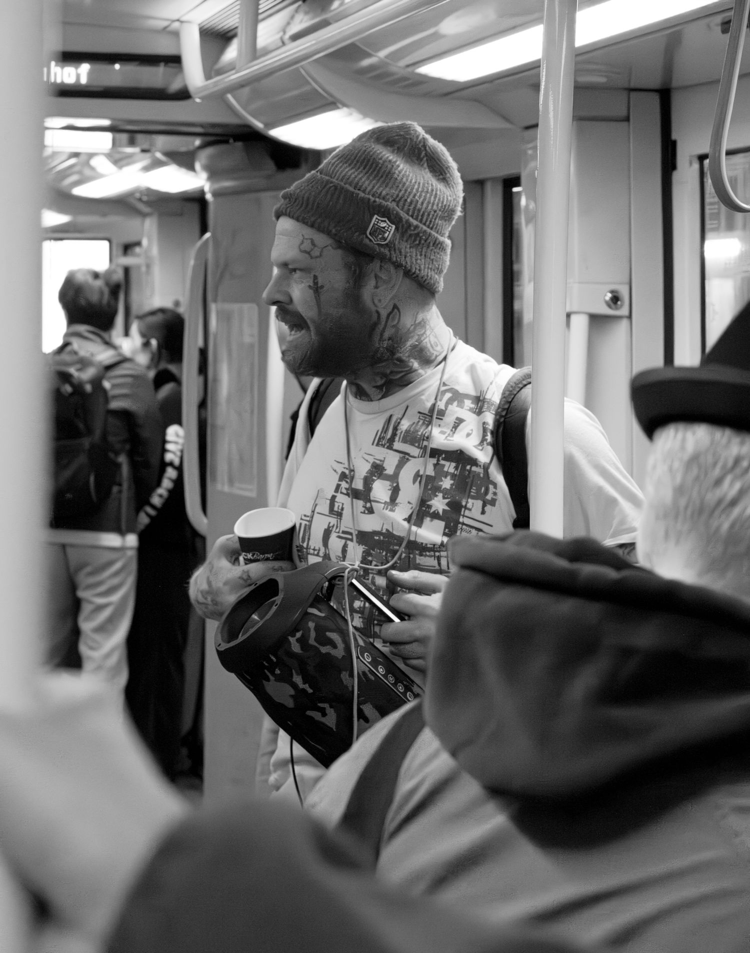 Black and white photo of passengers reading newspapers on public transit.