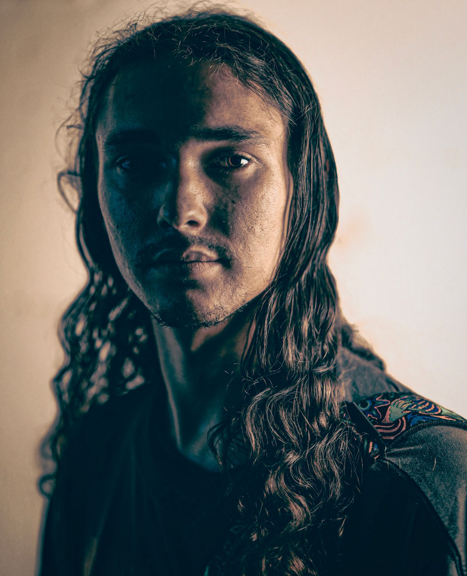 Series of moody portrait photographs showing dark-haired subject in warm lighting against neutral background.