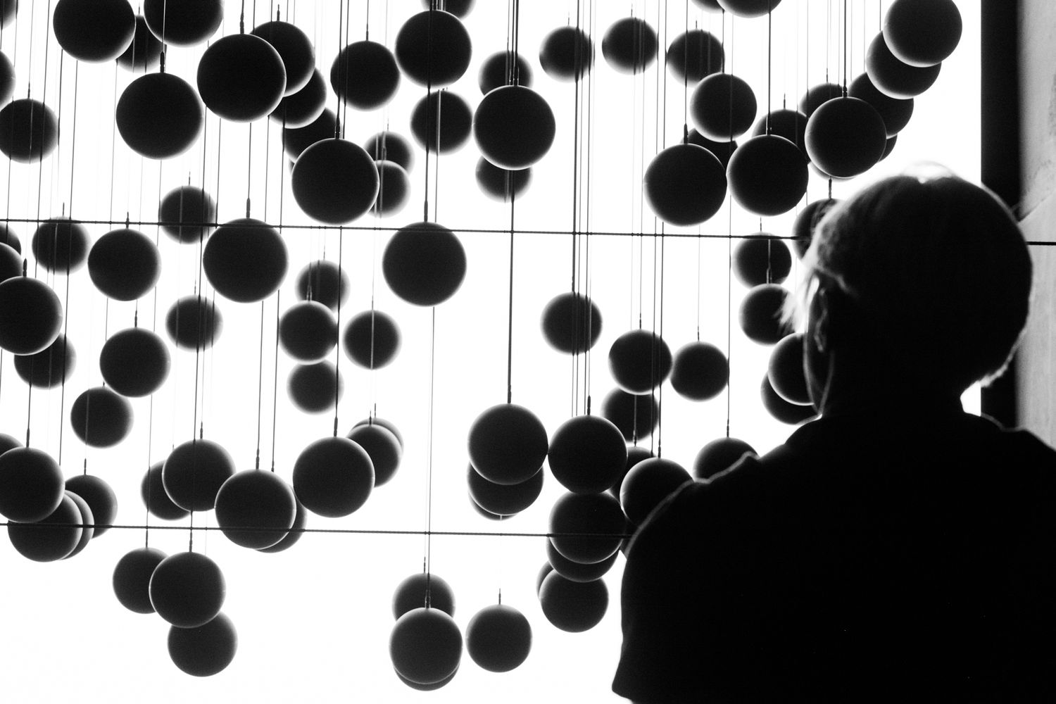 Black paper lanterns hanging from ceiling in geometric pattern.
