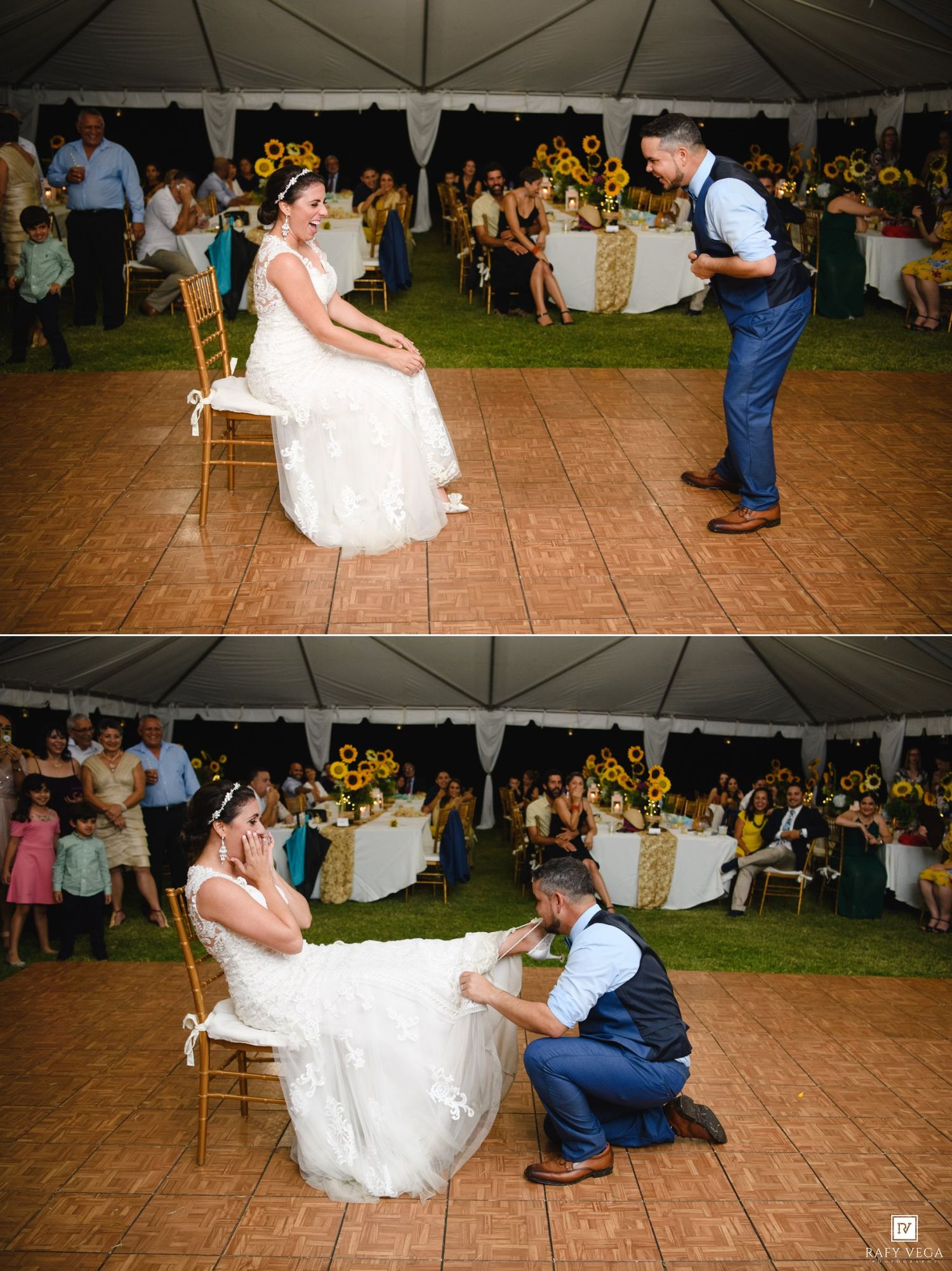 Groom removes garter from bride sitting on chair at outdoor wedding reception decorated with sunflowers.