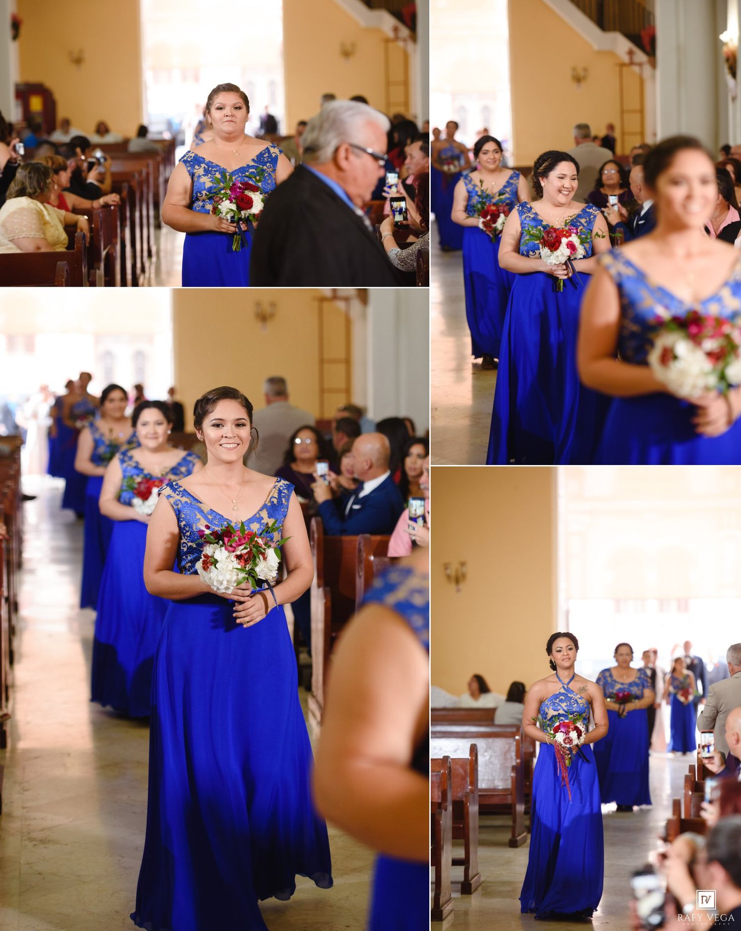 Bridesmaids in royal blue gowns walk down the church aisle holding bouquets during a wedding ceremony.
