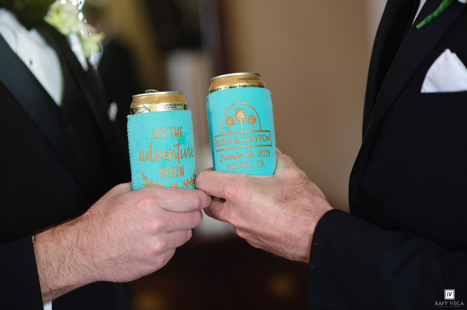 Two grooms toasting with teal custom wedding koozies at their wedding reception celebration.