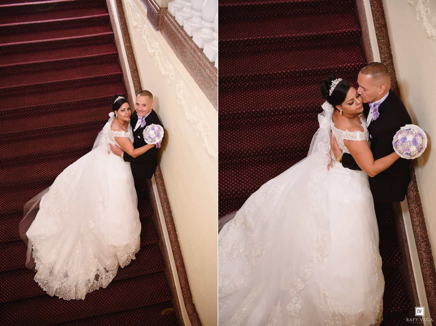 Bride in white ball gown and groom in black tuxedo pose romantically on elegant red carpeted staircase.