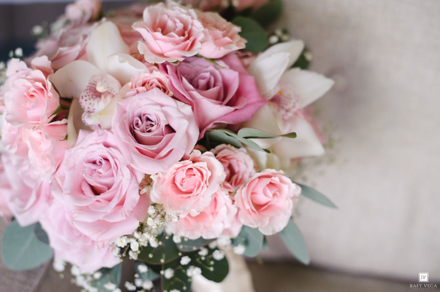 A bridal bouquet of soft pink roses and baby's breath, elegantly arranged for a wedding ceremony.