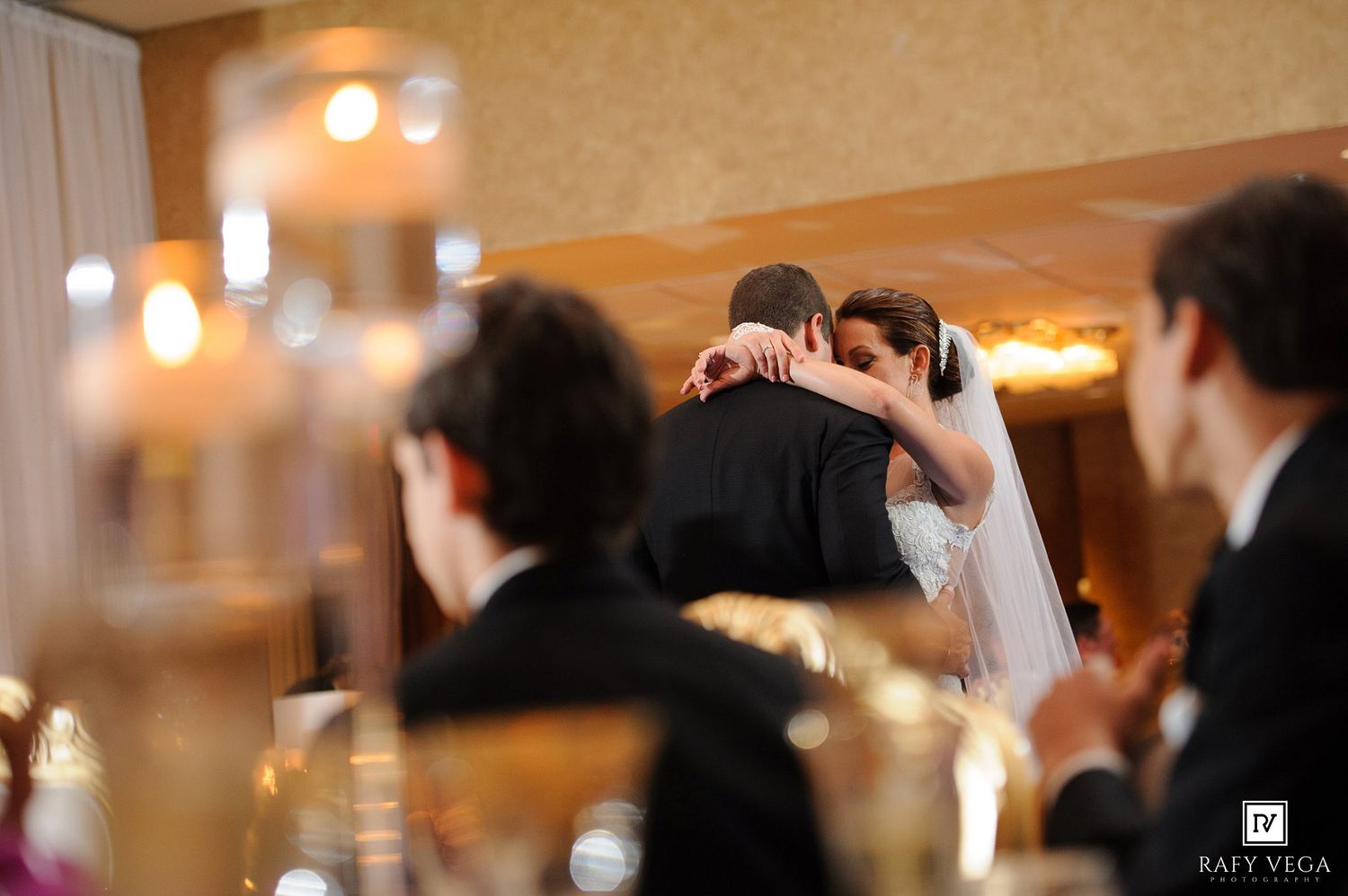 Bride and groom share an emotional first dance embrace at their elegant wedding reception.