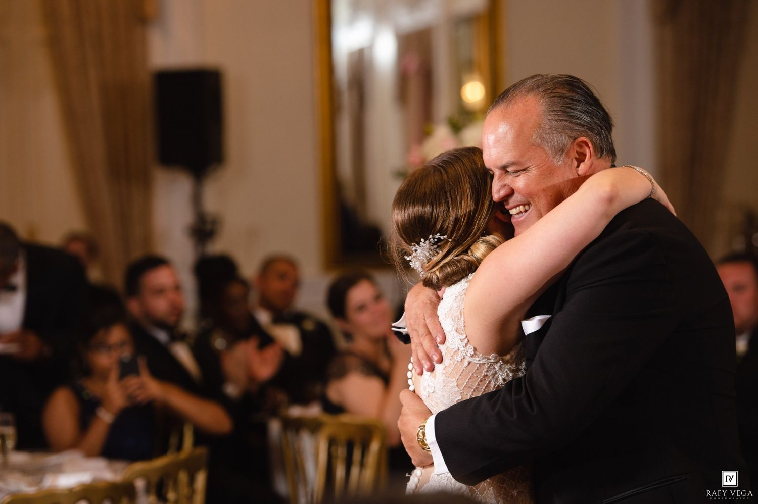 Father and bride share an emotional hug during father-daughter dance at elegant wedding reception.
