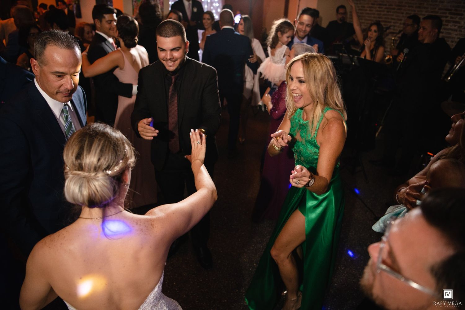 Guests dancing and celebrating at an elegant wedding reception party on a crowded dance floor.