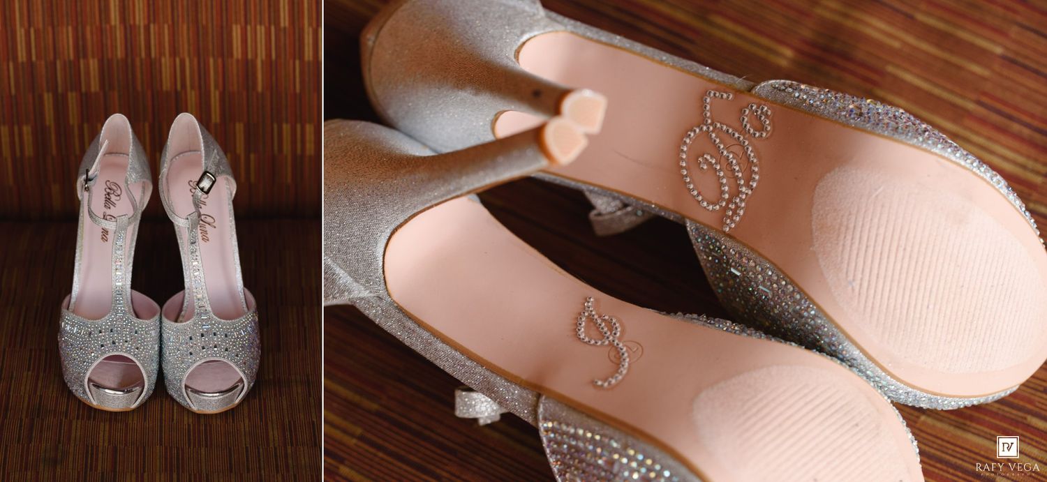 Sparkling silver glitter peep-toe wedding heels displayed on wood floor, with close-up showing monogram initials on insoles.