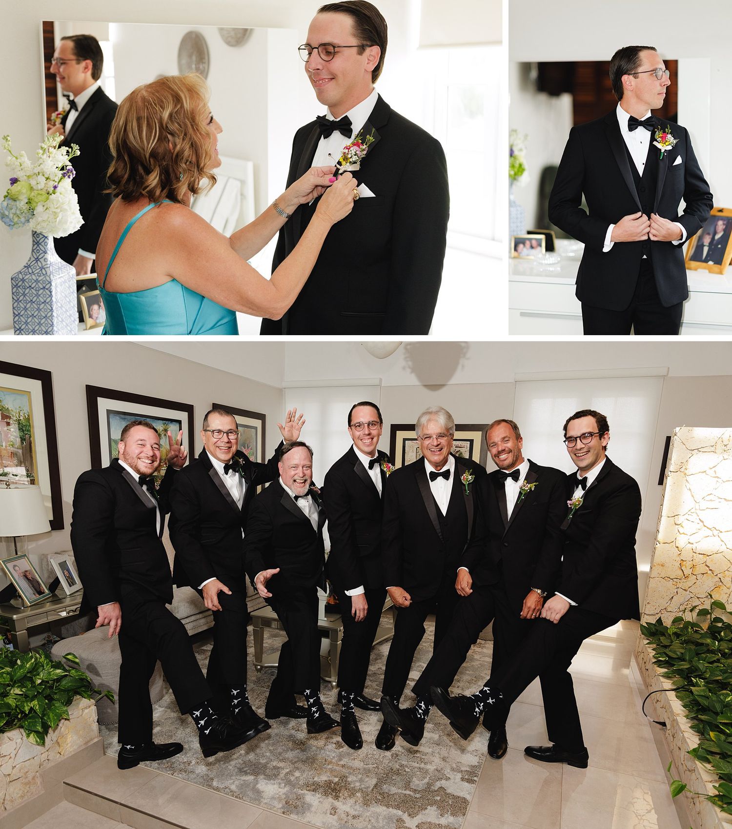 Groom getting boutonniere pinned by woman in teal dress, with groomsmen in black tuxedos posing together indoors.
