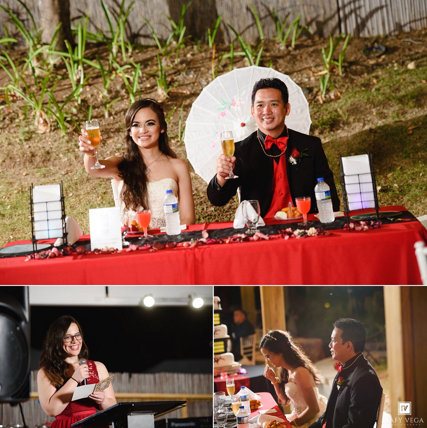 Bride and groom toast at red-draped sweetheart table with white parasol backdrop at Asian-themed wedding reception.