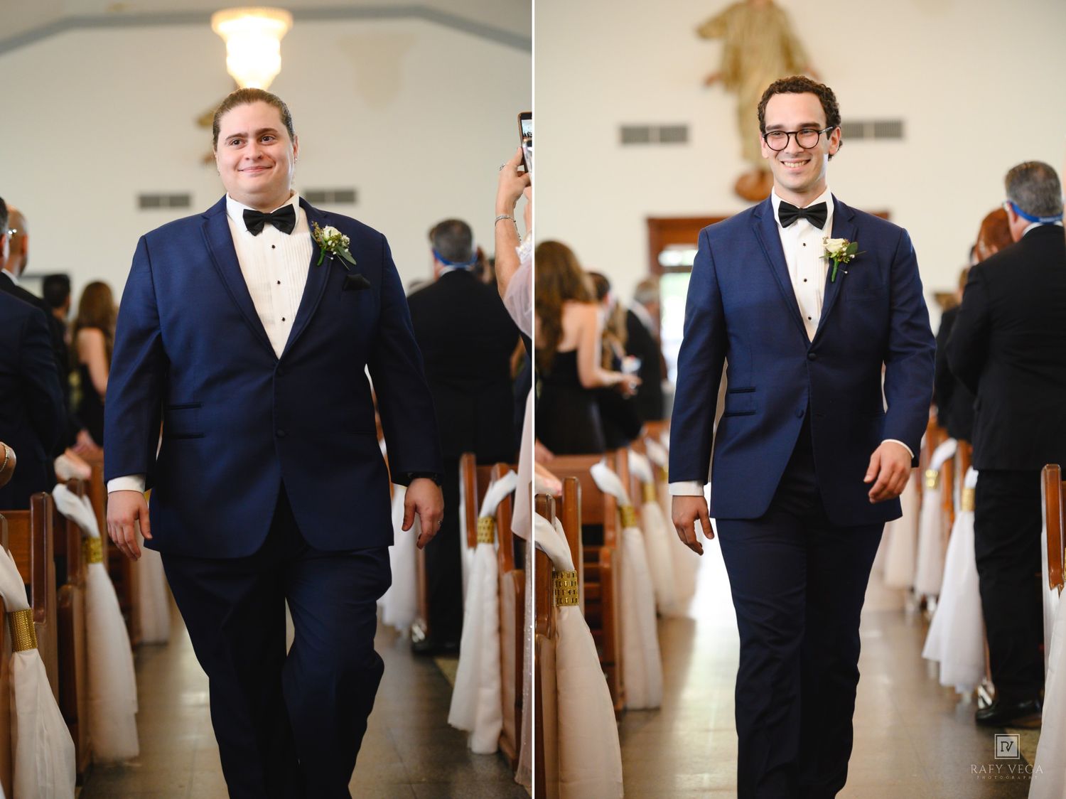 Groom in navy tuxedo with bow tie walking down church aisle smiling at wedding ceremony.