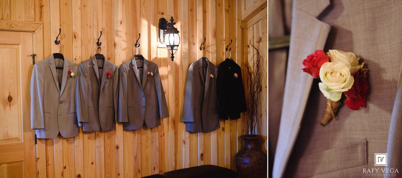 Groom suits hanging on wooden wall hooks beside a lantern, with a red and yellow boutonniere detail closeup.