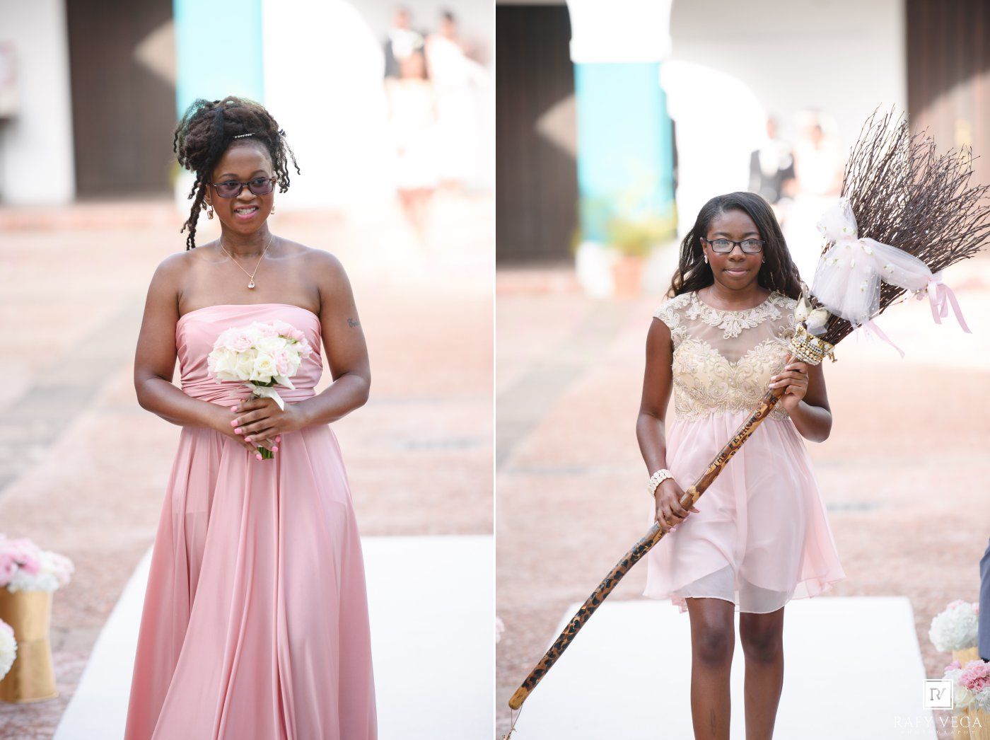 Two women in pink dresses at a wedding, one holding a bouquet and one holding a broom for a jumping the broom ceremony.