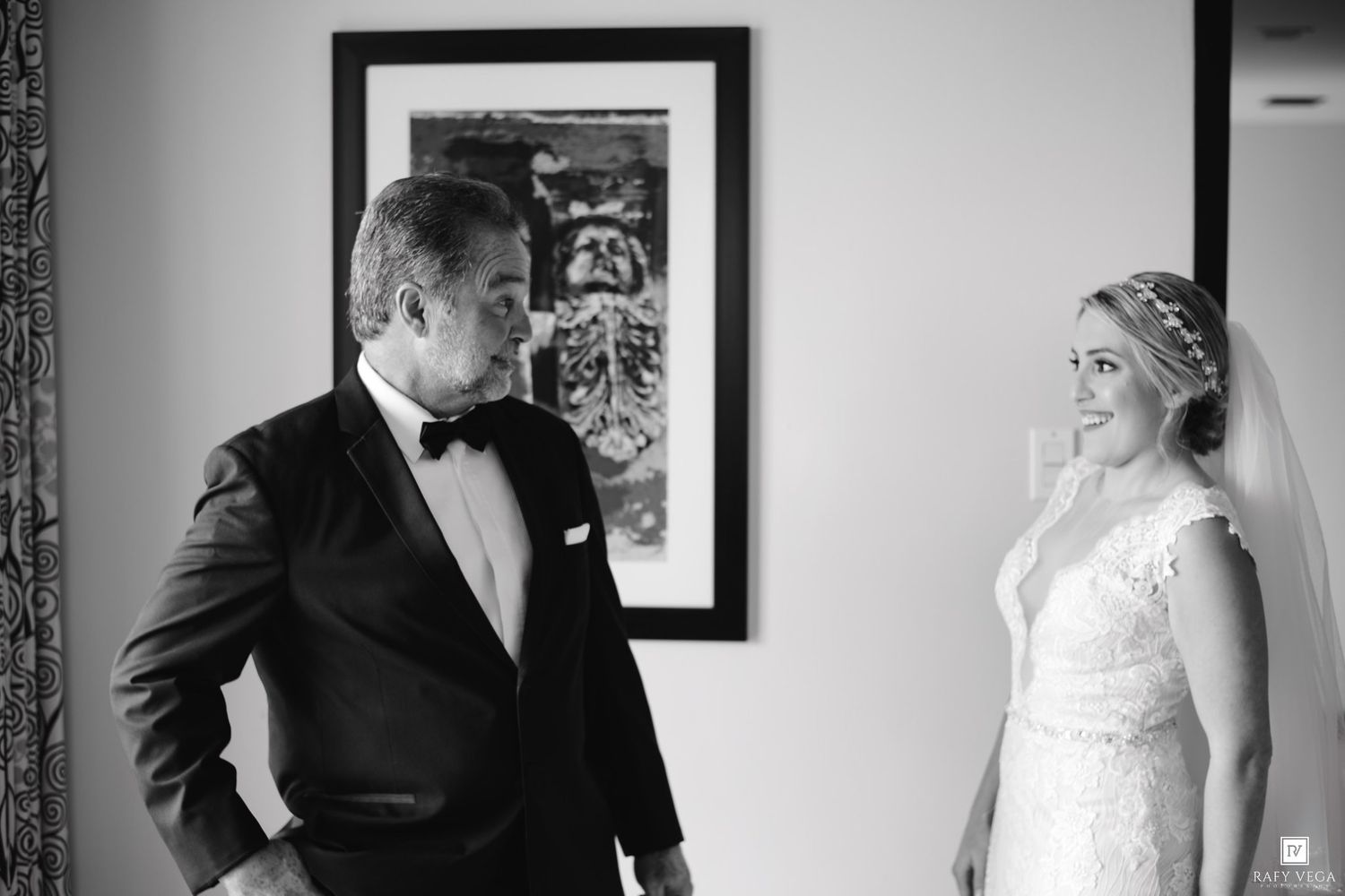 Father sees bride in wedding dress for the first time in emotional black and white photo.