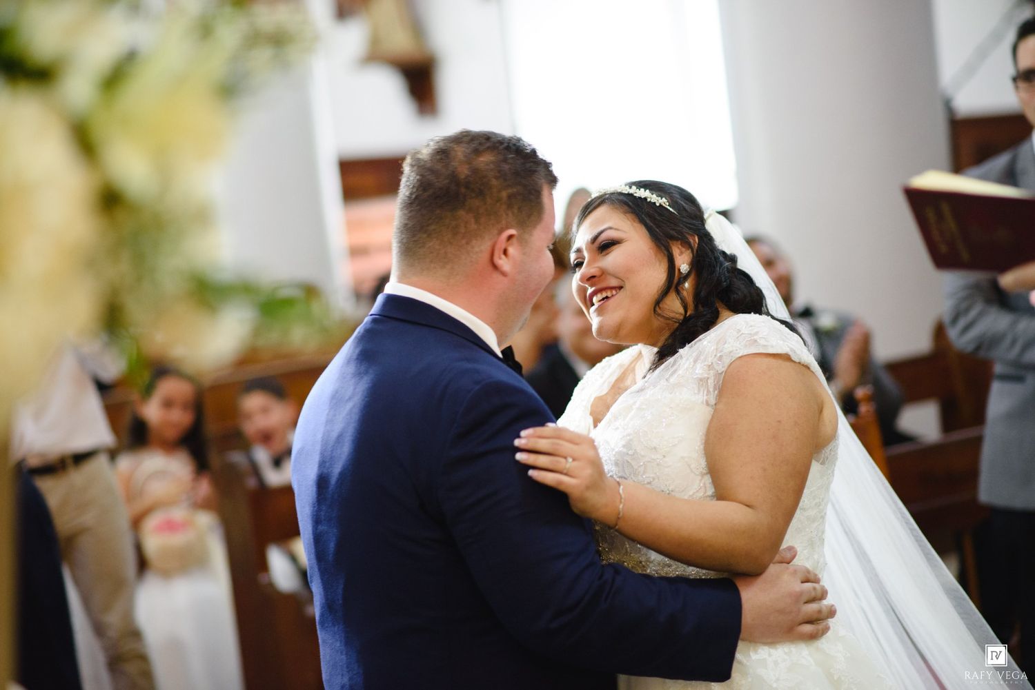 A joyful bride and groom share an intimate moment at the altar during their church wedding ceremony.