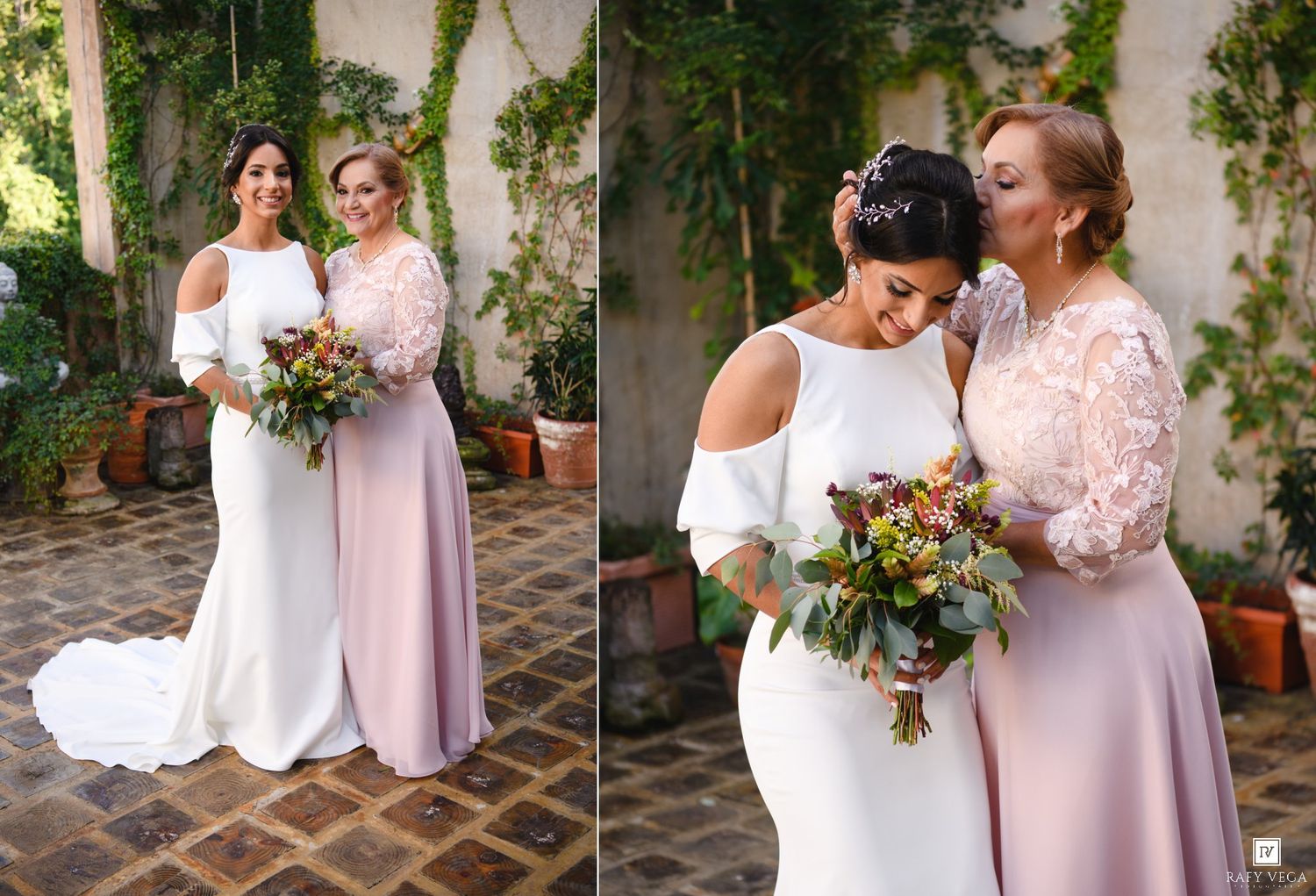 Bride and bridesmaid in white and dusty rose gowns holding bouquets in a garden courtyard.